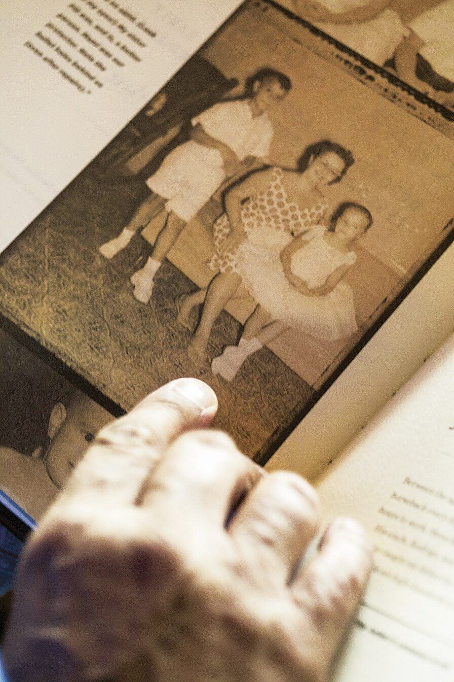 In a photo from his childhood in Cuba, he poses with his mother and sister.
