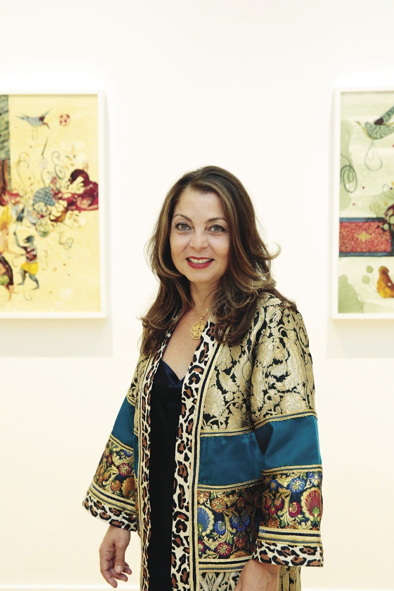 Neda Nobari, who frequently supports the work of international artists, is photographed with paintings by Iranian-American Shiva Ahmadi.