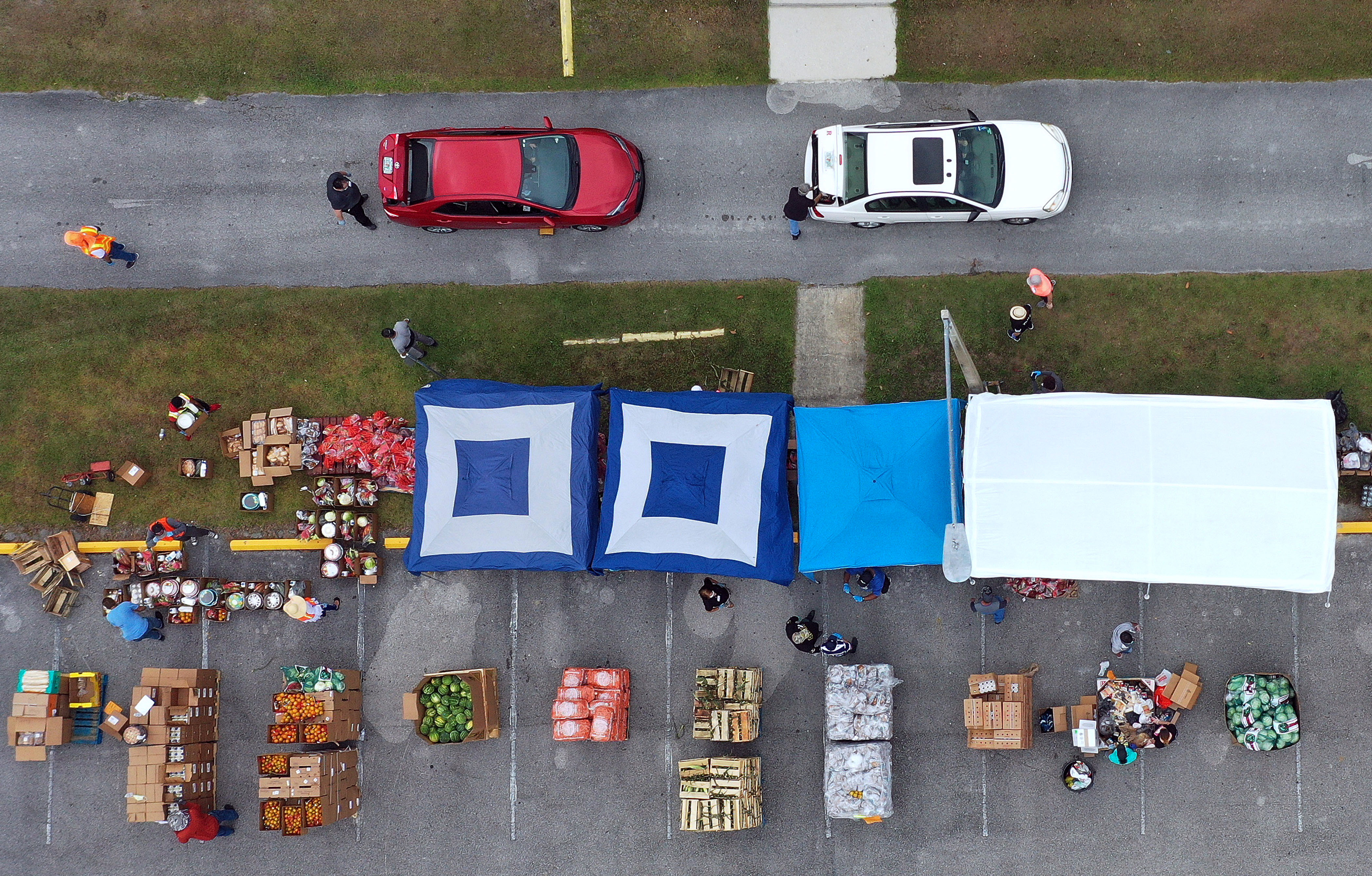 In this aerial view, volunteers distribute food from the Second Harvest Food Bank of Central Florida to needy families at a drive through event on April 17, 2020 at the New Jerusalem Church in Kissimmee, Florida. Food banks across the United States are experiencing a surge in demand as unemployment numbers increase due to layoffs caused by the coronavirus (COVID-19) pandemic.