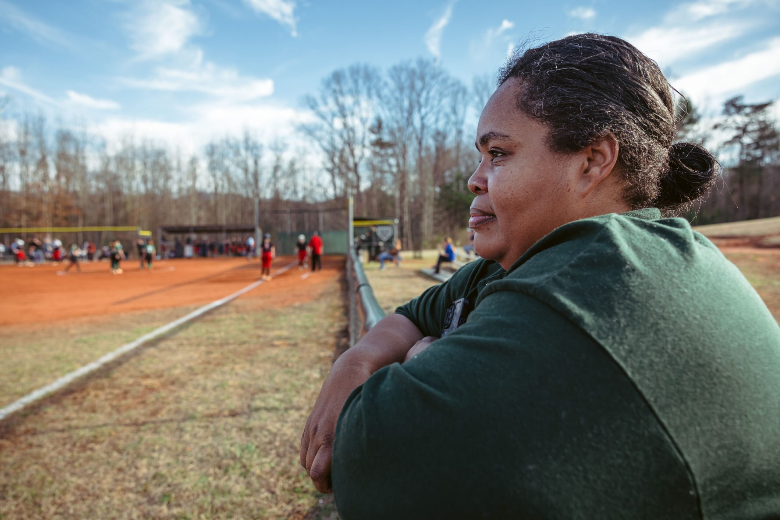 Takiyah McCathern, the assistant principal at Central Wilkes Middle School, watches the girls softball team play against West Wilkes Middle School at the field behind the school  in Moravian Falls, NC on March 4, 2024. McCathern has used hyperlocal grants at the school to help student athletes with the cost of playing sports.