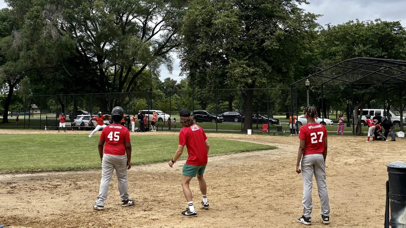 Rollie Olson, center, volunteers as a coach for a teen baseball team, the Garfield Gladiators, on the West Side of Chicago.
