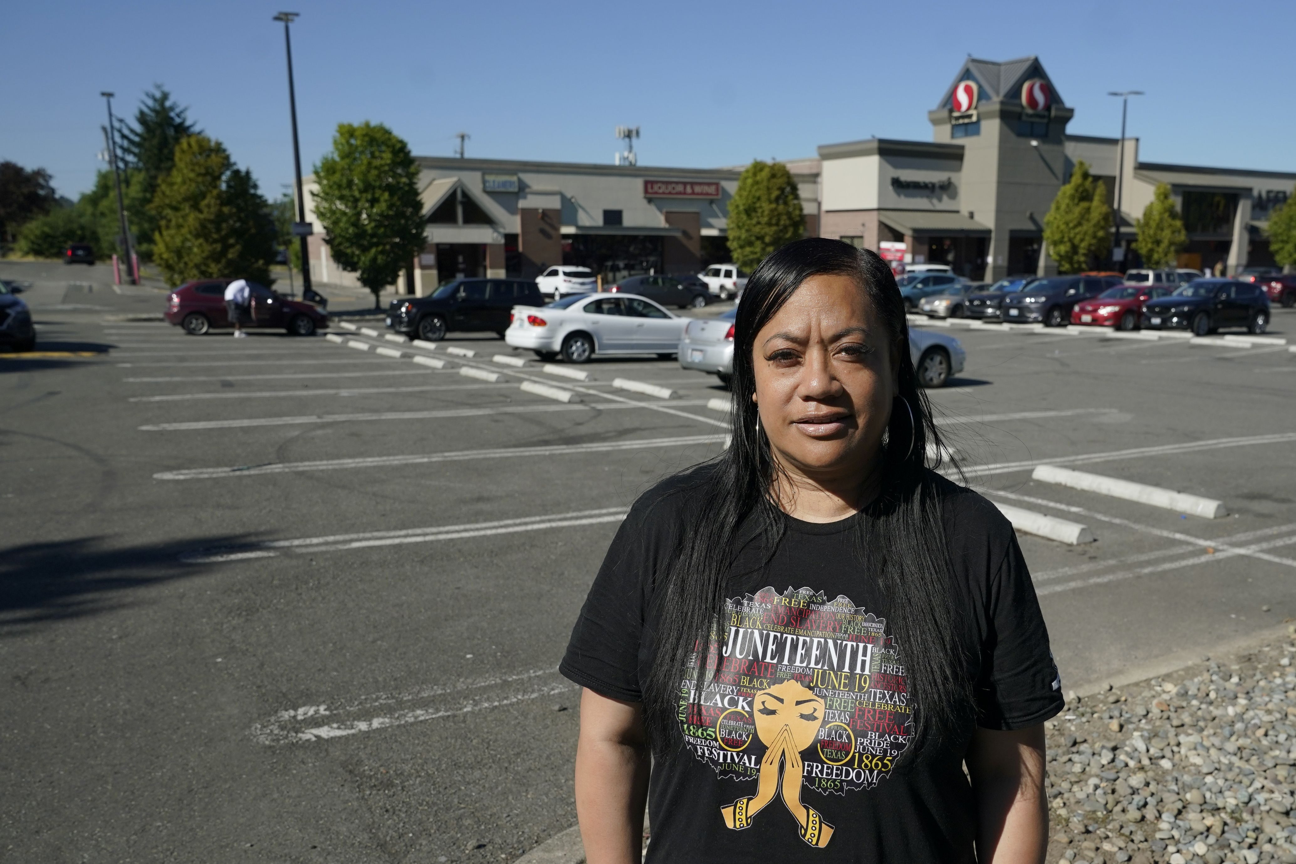 Marty Jackson, director of the SE Network, a community group whose work includes increasing the safety of community gathering places, poses for a photo, Tuesday, July 12, 2022, in the parking lot of a Safeway store in Seattle’s Rainier Beach neighborhood, where her group holds weekly gatherings to provide food, referrals to services and “healing spaces” for people affected by violence. The work of Jackson’s group falls under the umbrella of strategies known as community violence intervention, an approach backed by the Biden administration and donations from several major philanthropic foundations, which tries to stop local conflicts from escalating. (AP Photo/Ted S. Warren)