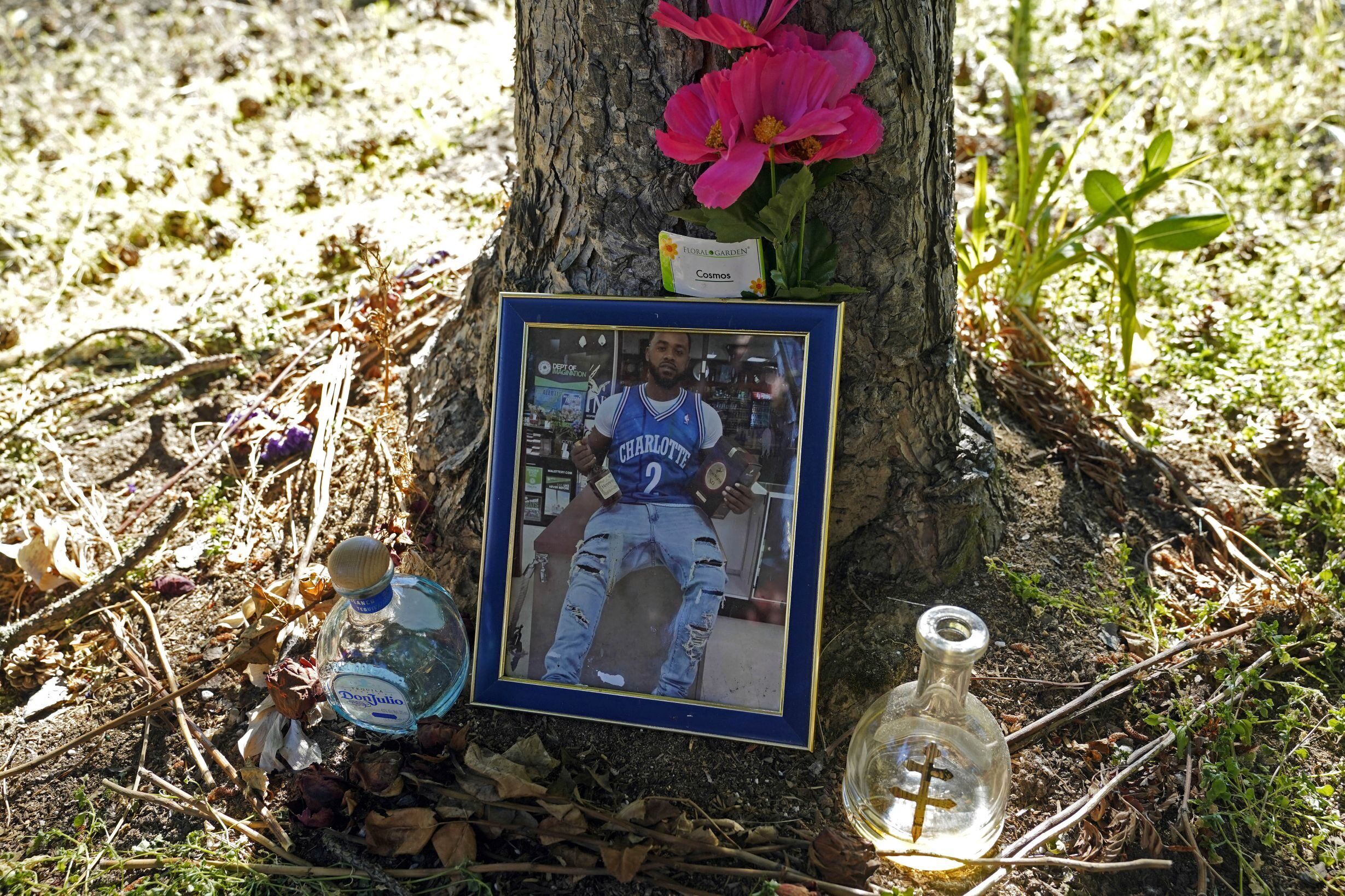 A memorial for Christopher Roberts Jr., who was killed in a 2020 shooting in the parking lot of a Safeway store in Seattle’s Rainier Beach neighborhood, is shown Tuesday, July 12, 2022 near where the shooting took place. The space is now where a community group holds weekly gatherings to provide food, referrals to services and “healing spaces” for people affected by violence, work that falls under the umbrella of strategies known as community violence intervention, an approach backed by the Biden administration and donations from several major philanthropic foundations, which tries to stop local conflicts from escalating. (AP Photo/Ted S. Warren)