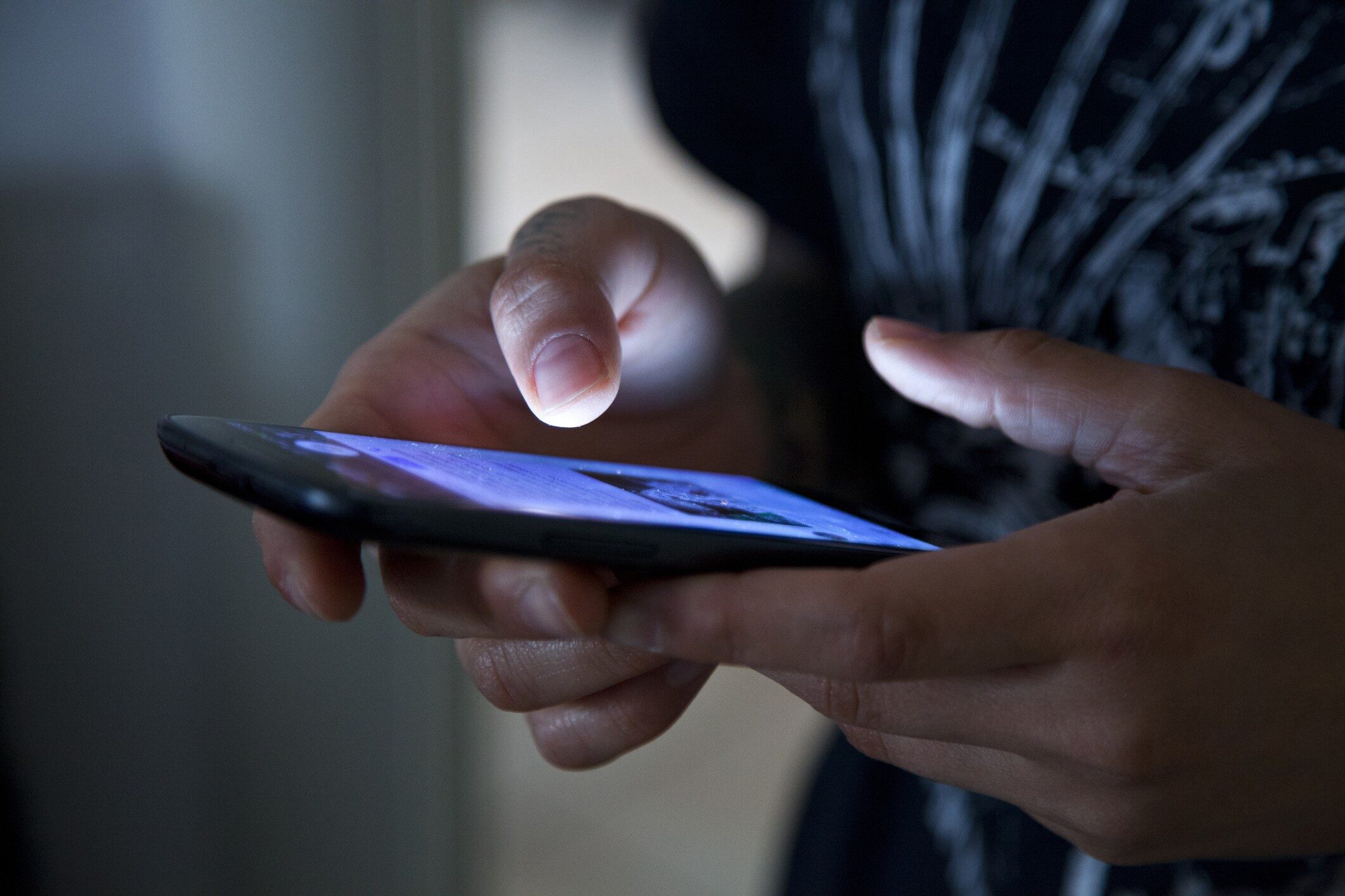photograph of a woman holding phone with screen with data privacy symbol