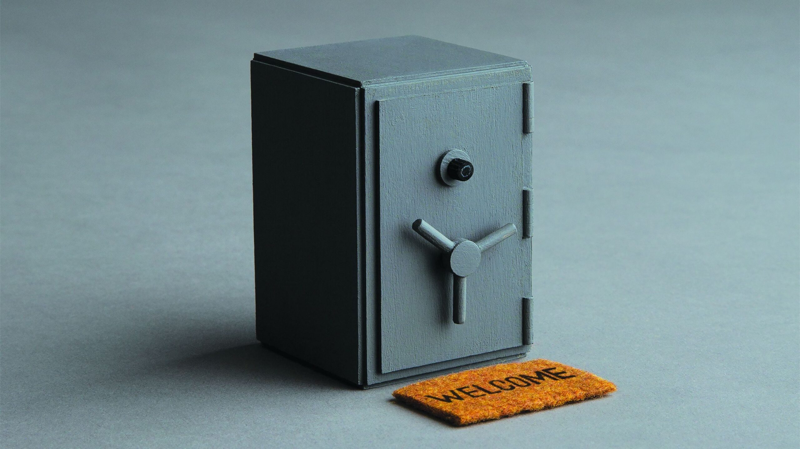 Photo illustration showing a welcome mat in front of the door of a bank safe