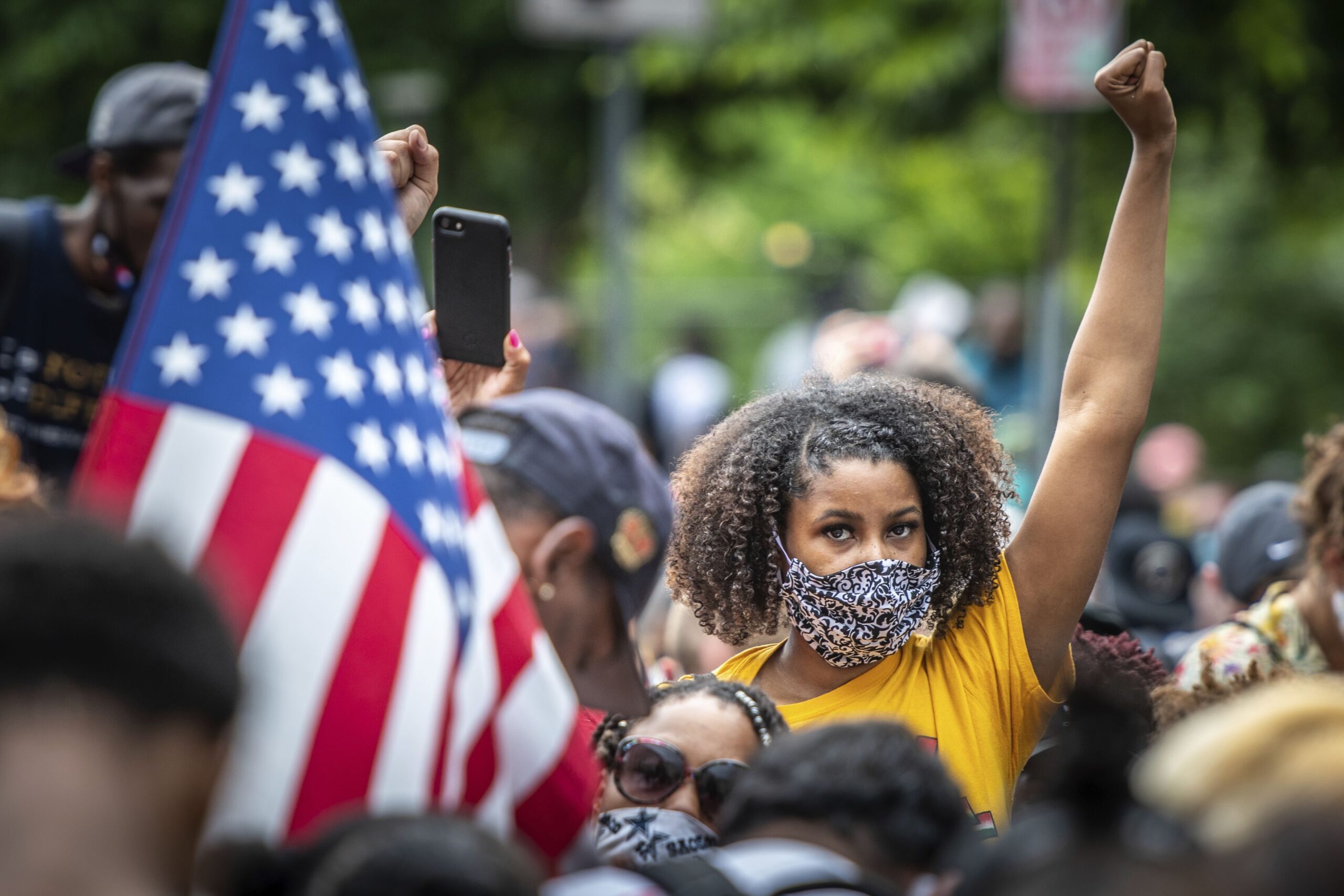 A woman raises her fist while participating in a Black Lives Matter protest outside the White House in June 2020, in Washington, D.C.