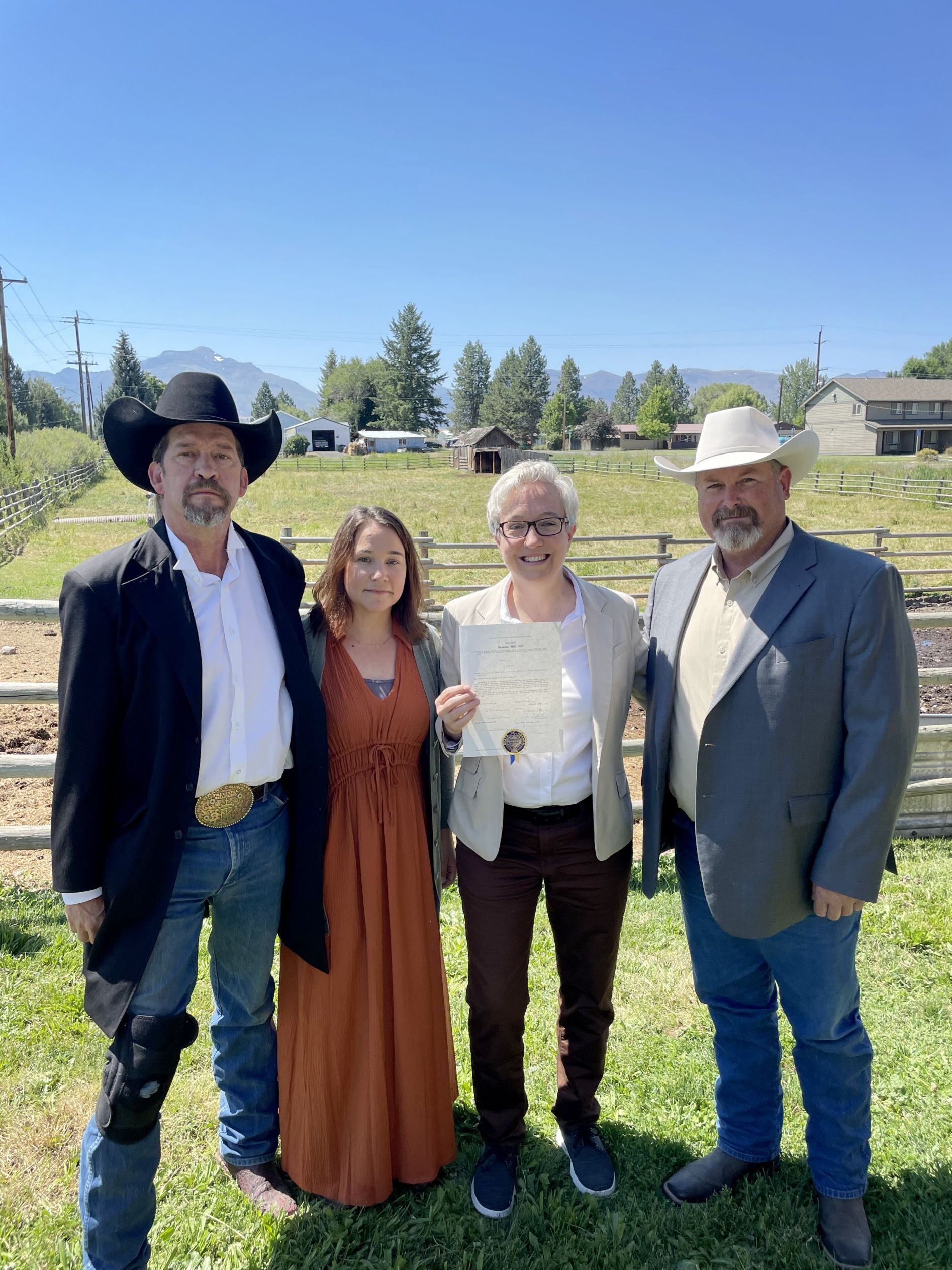 From left, Jim Hamsher, county judge in Grant County, Allison Myers, Family and Community Health program leader at Oregon State University’s College of Health, Oregon Gov. Tina Kotek, and Oregon State Sen. Todd Nash  pose for a photo with a copy of Oregon Senate Bill 955, establishing the state’s link into the AgriStress Helpline, in Prairie City, Ore., on July 17, 2023.