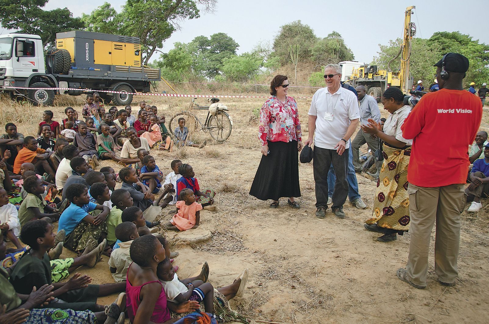 CHANGE AGENTS: David and Dana Dornsife (center) talk with residents of a village in Zambia. They gave $40 million in 2015 to support clean-water efforts. 