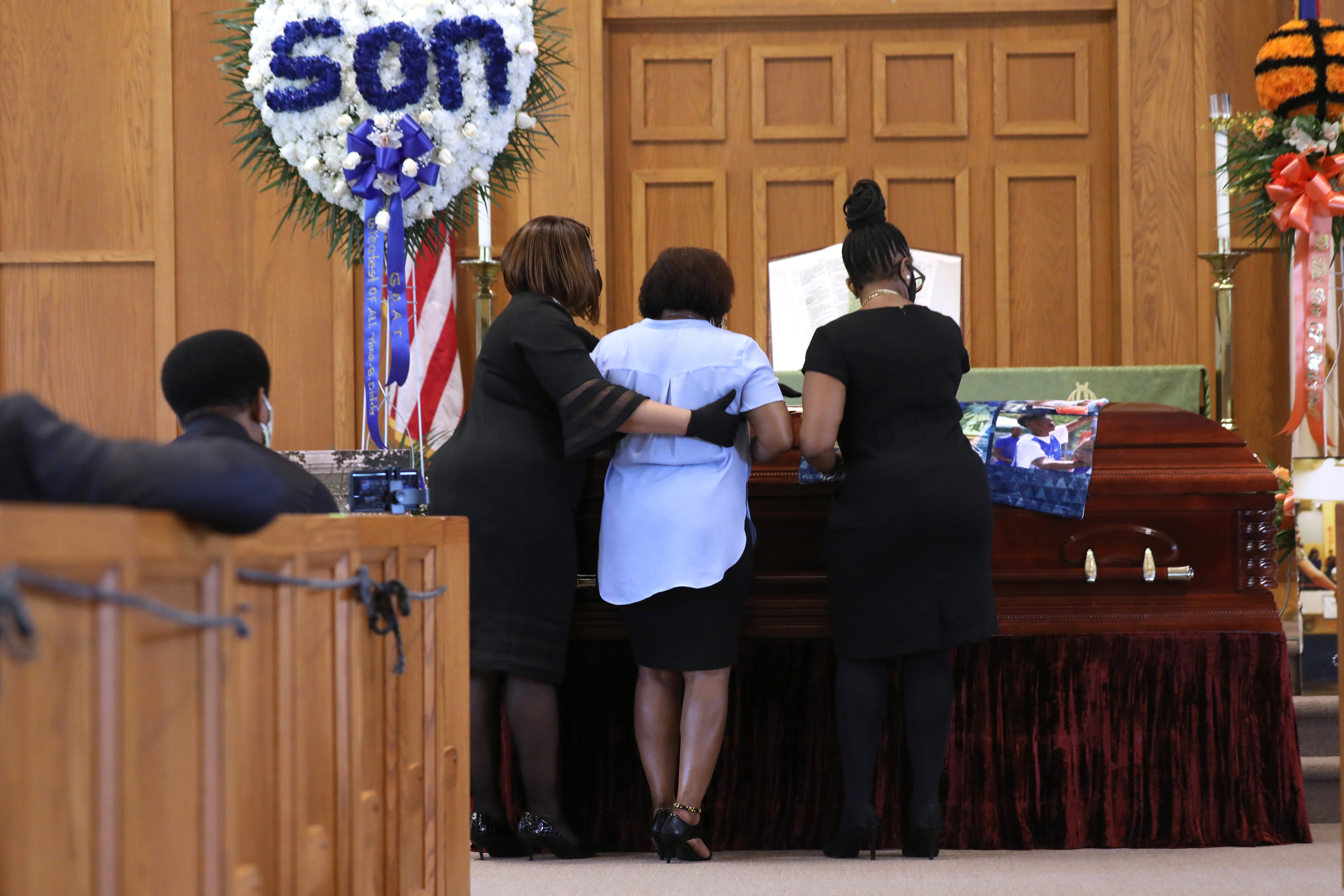The mother of Brandon Hendricks-Ellison grieves over his casket at his funeral after the young basketball star was fatally shot in the Bronx days after graduating from high school on July 15, 2020 in Bronxville, New York.