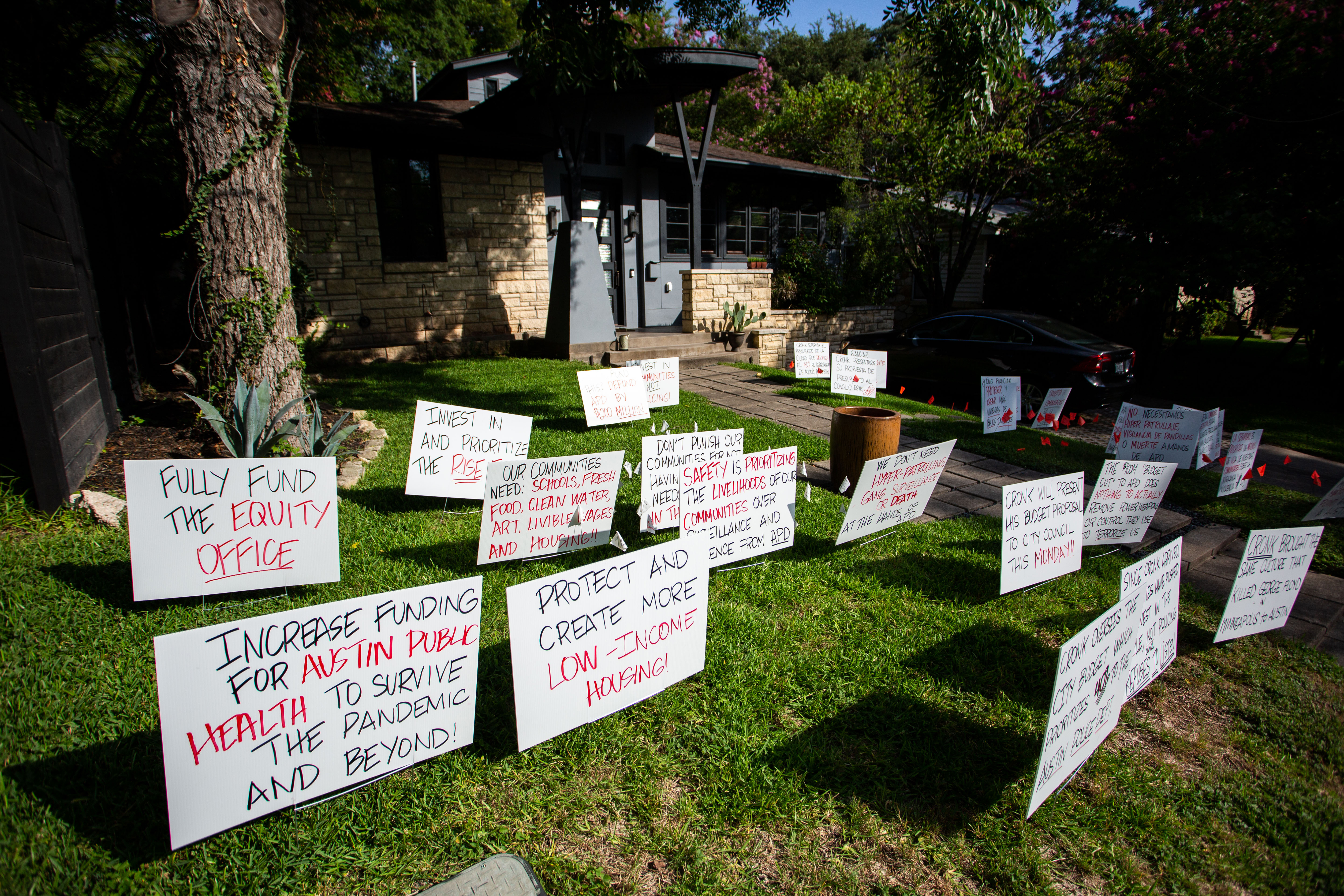 Signs in front of Austin City Manager Spencer Cronk’s home demanding the next city budget move funding away from police and toward social services.