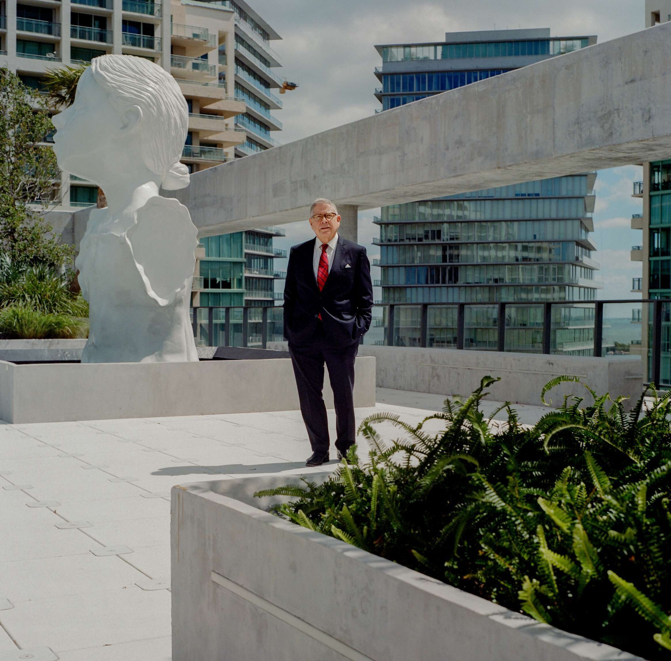 Alberto Ibargüen standing next to, “The Well” by Enrique Martinez Celaya, on the rooftop sculpture garden in Coconut Grove Florida where the foundation offices are located.