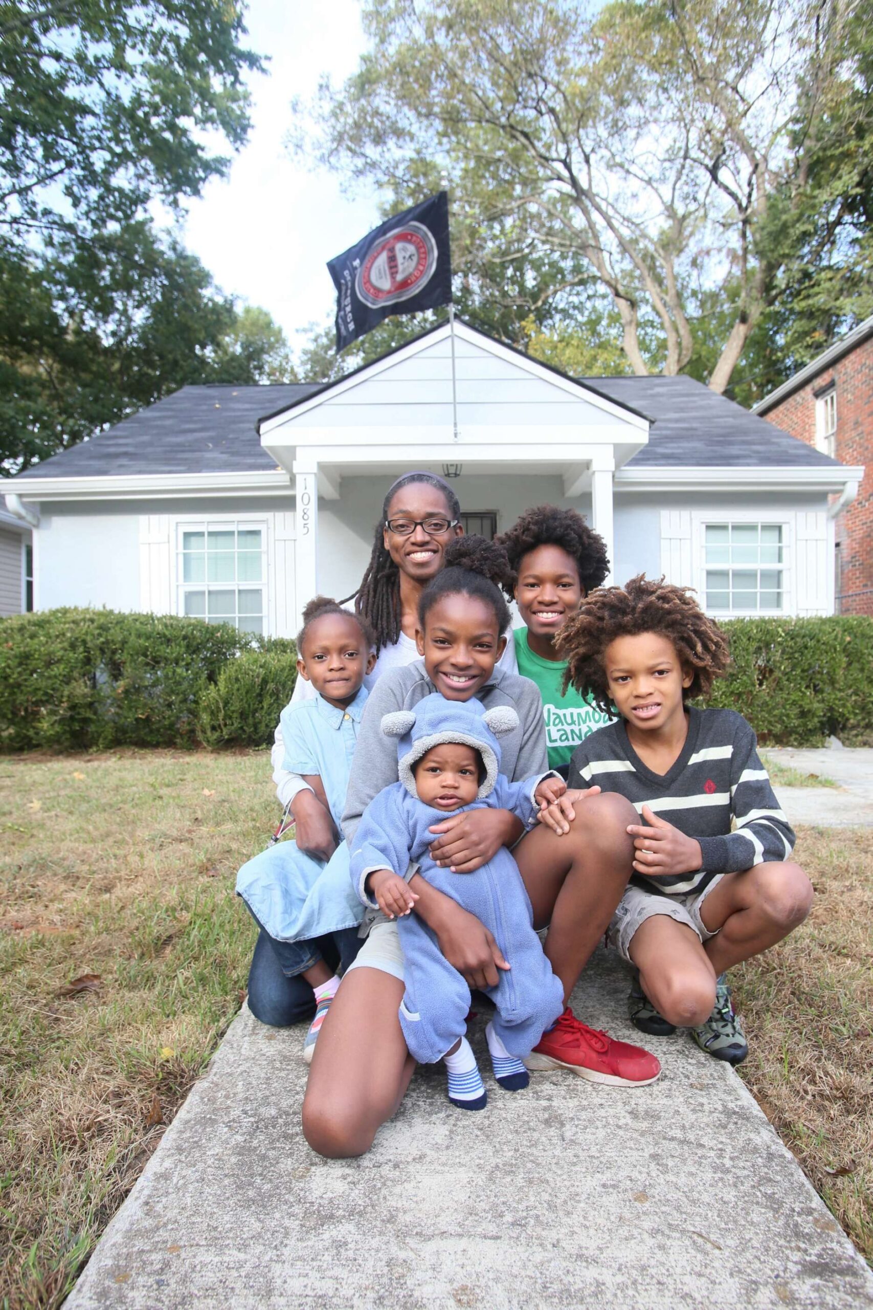 Makeisha Robey (rear center) and her children pose in front of the home they purchased through Atlanta Land Trust.