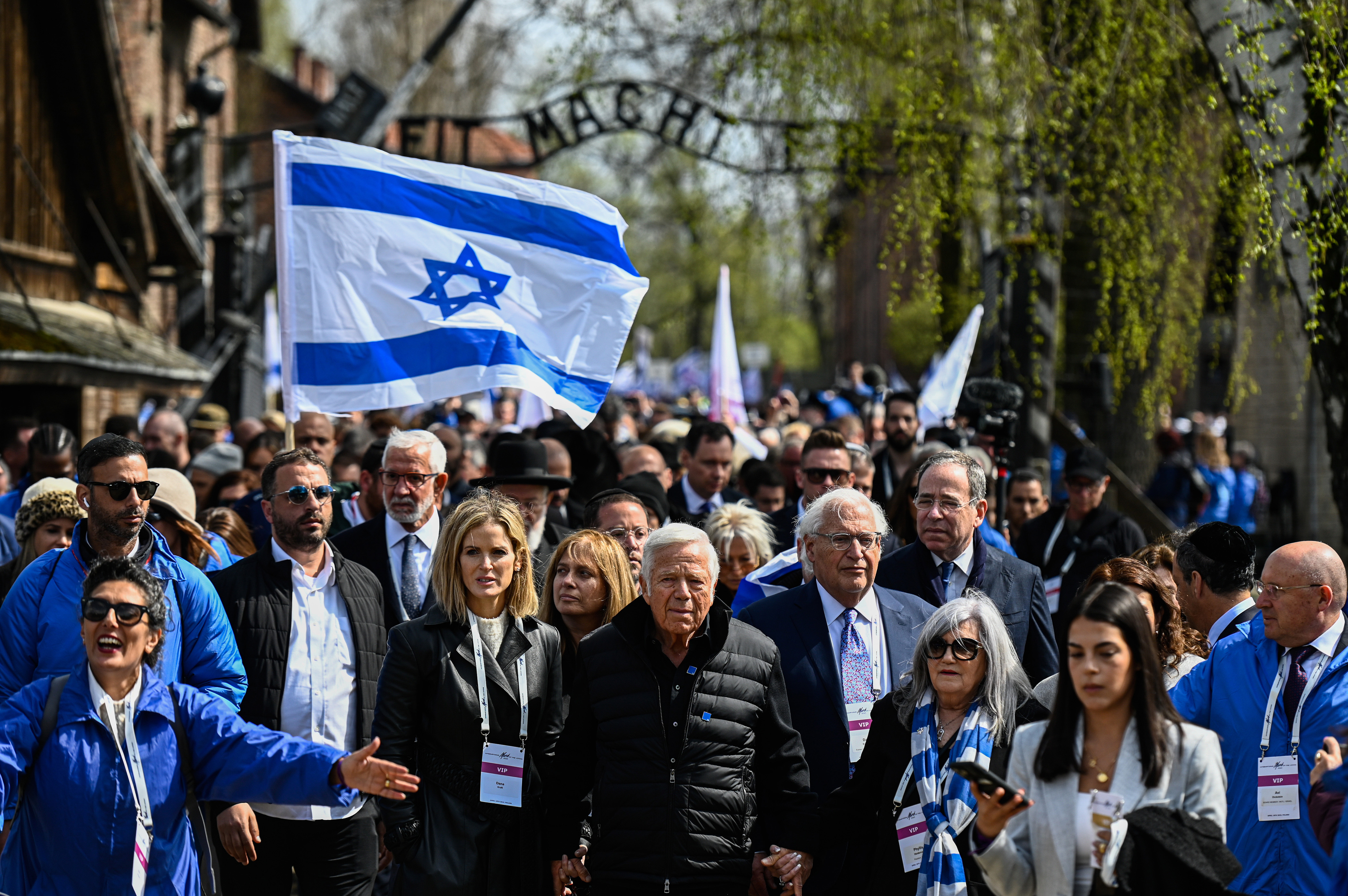 OSWIECIM, POLAND - APRIL 18: American businessman Robert Kraft (center) joins participants as they walk past the main gate of the former Auschwitz Concentration Camp during 35th March of the Living at the former Auschwitz I site on April 18, 2023 in Oswiecim, Poland. An educational program aimed at Jewish youth from around the world to better understand the history of the Holocaust, called the March of the Living, has taken place annually since 1988, except for the 2020 Covid-19 hiatus. (Omar Marques, Getty Images)