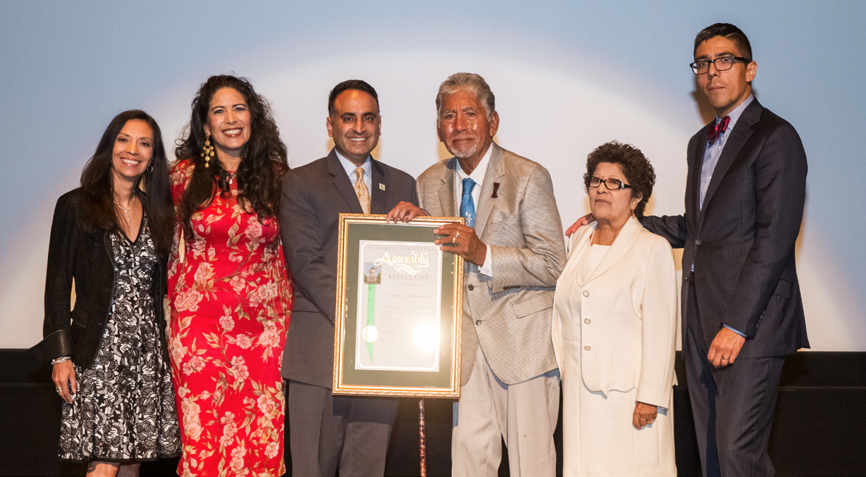 Assemblymember Ash Kalra presents the family with a proclamation at the 15th anniversary.
