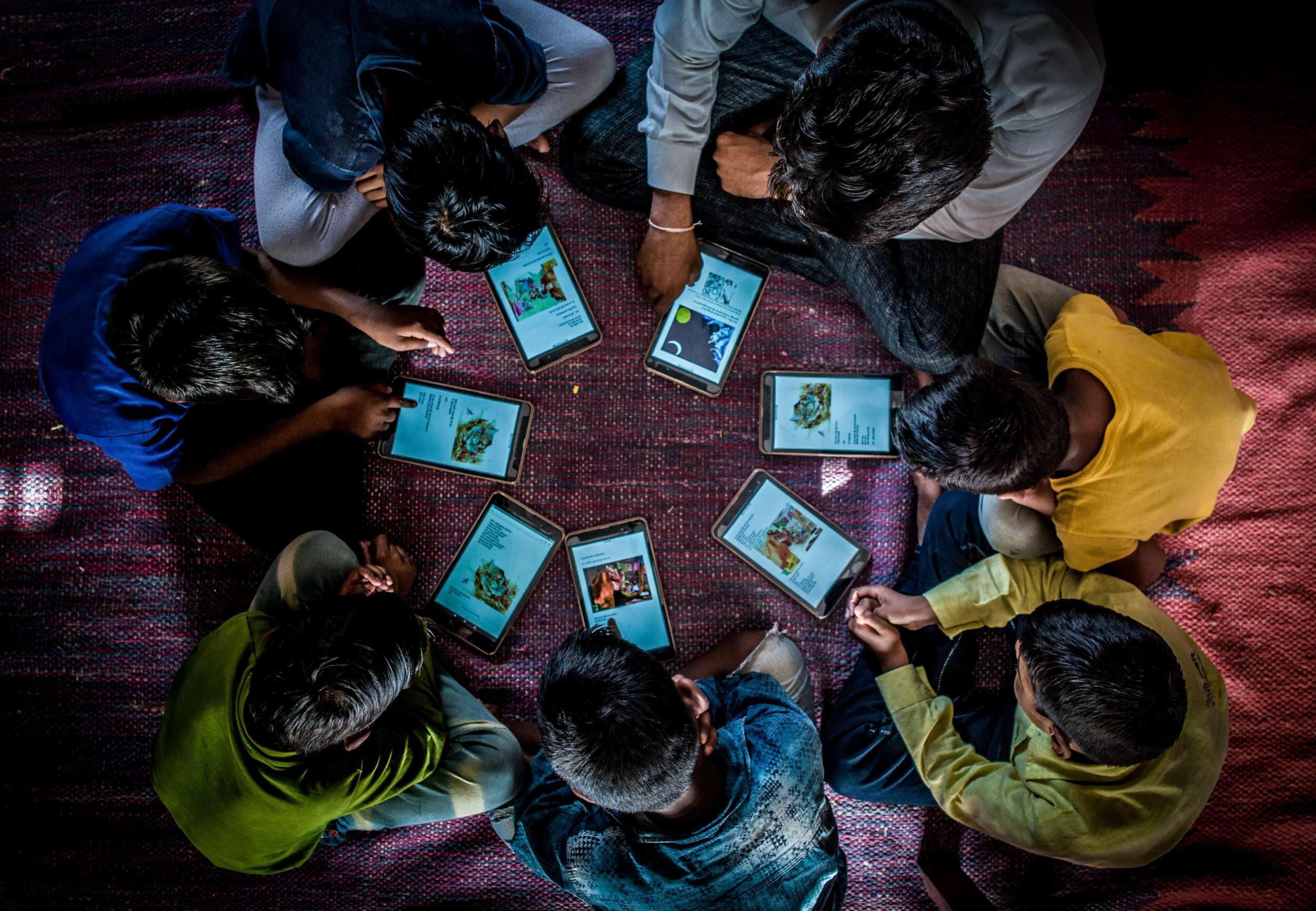 Students reading late-night stories from the Worldreader library at the Barefoot College Night School in Rajasthan, India.