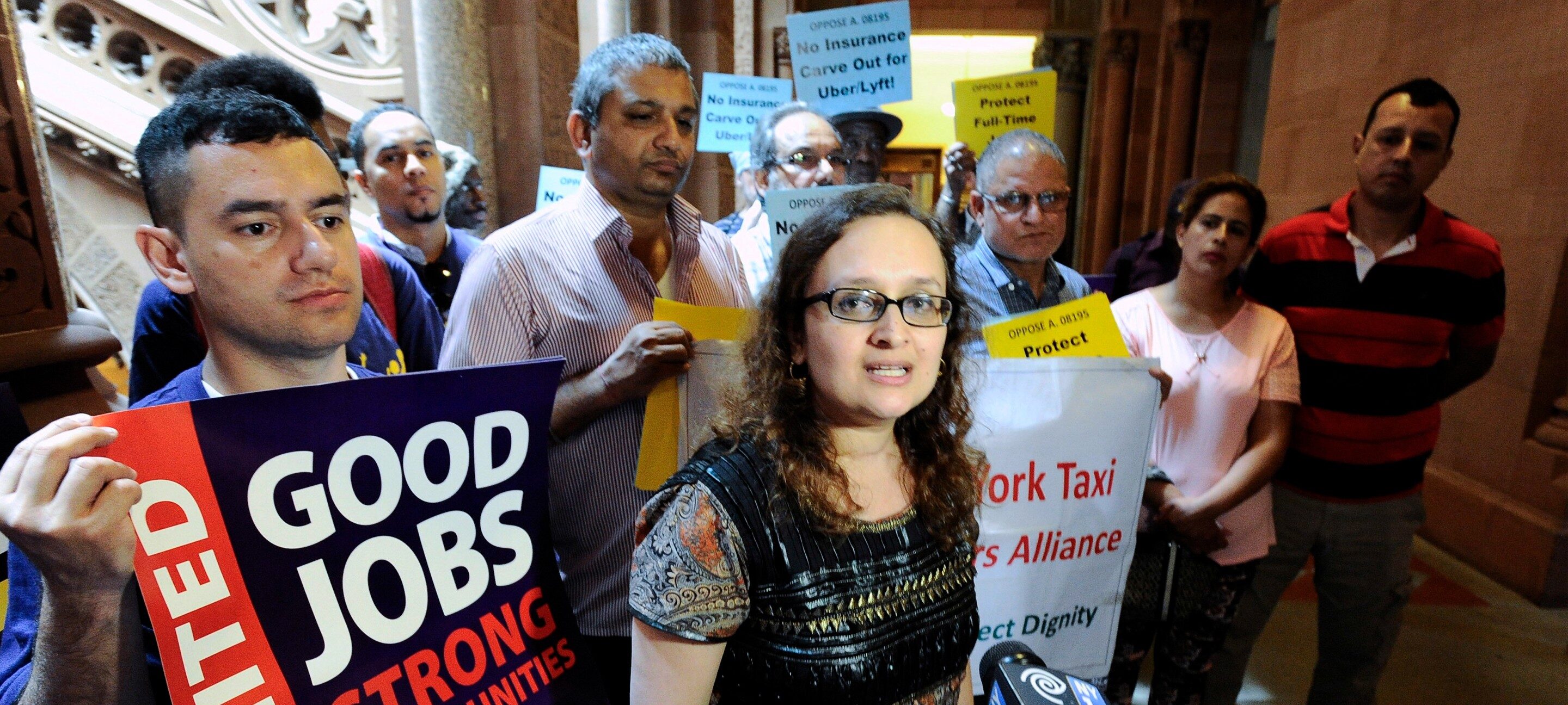 In this June 1, 2016 file photo, Bhairavi Desai, executive director of the New York Taxi Workers Alliance, center, speaks to reporters against allowing Uber and other app-based drivers to expand service to upstate New York, at the state Capitol on in Albany, N.Y. New York state lawmakers are considering legislation that would allow Uber and&nbsp;Lyft to expand into upstate cities like Buffalo, Syracuse, Albany and Rochester.&nbsp;The app-based ride-hailing services are now prohibited from operating outside of&nbsp; the New York City area. (AP Photo/Hans Pennink, File)