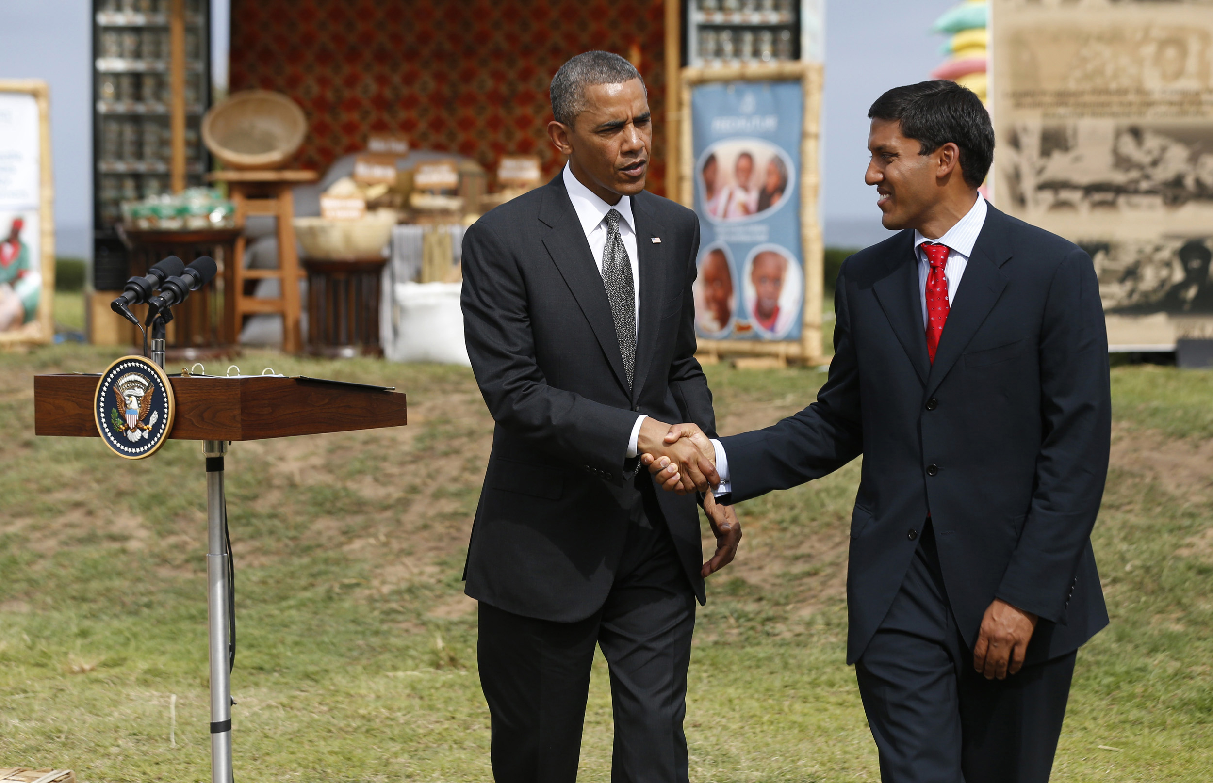 U.S. President Barack Obama shakes hands with Rajiv Shah, director of USAID, as he  visits a food security expo in Dakar June 28, 2013.