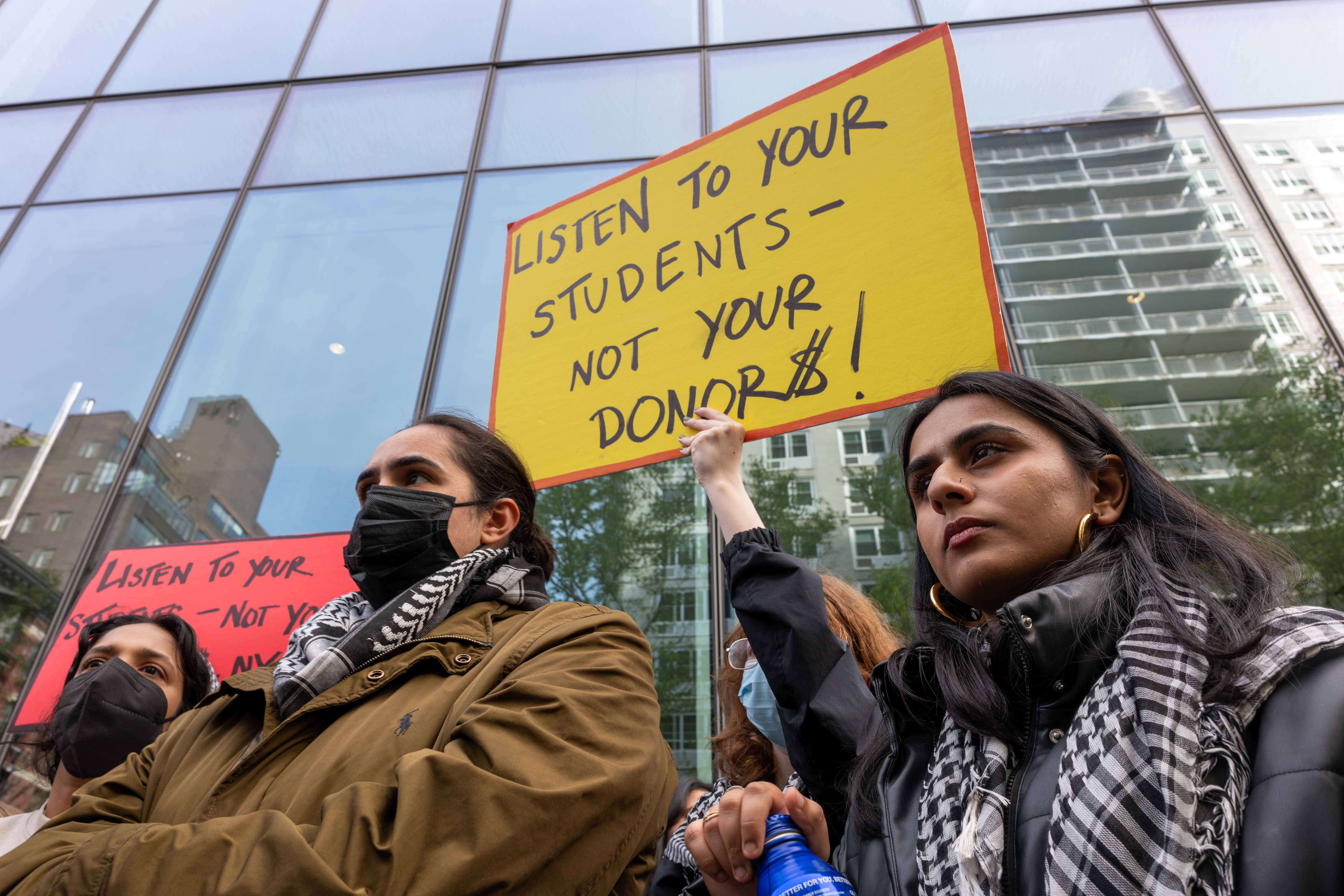 Pro-Palestinian protesters, including one holding up a sign that reads "Listen to your students not your donor$," gather outside of New York University buildings in lower Manhattan during ongoing demonstrations about school investments on May 3, 2024.