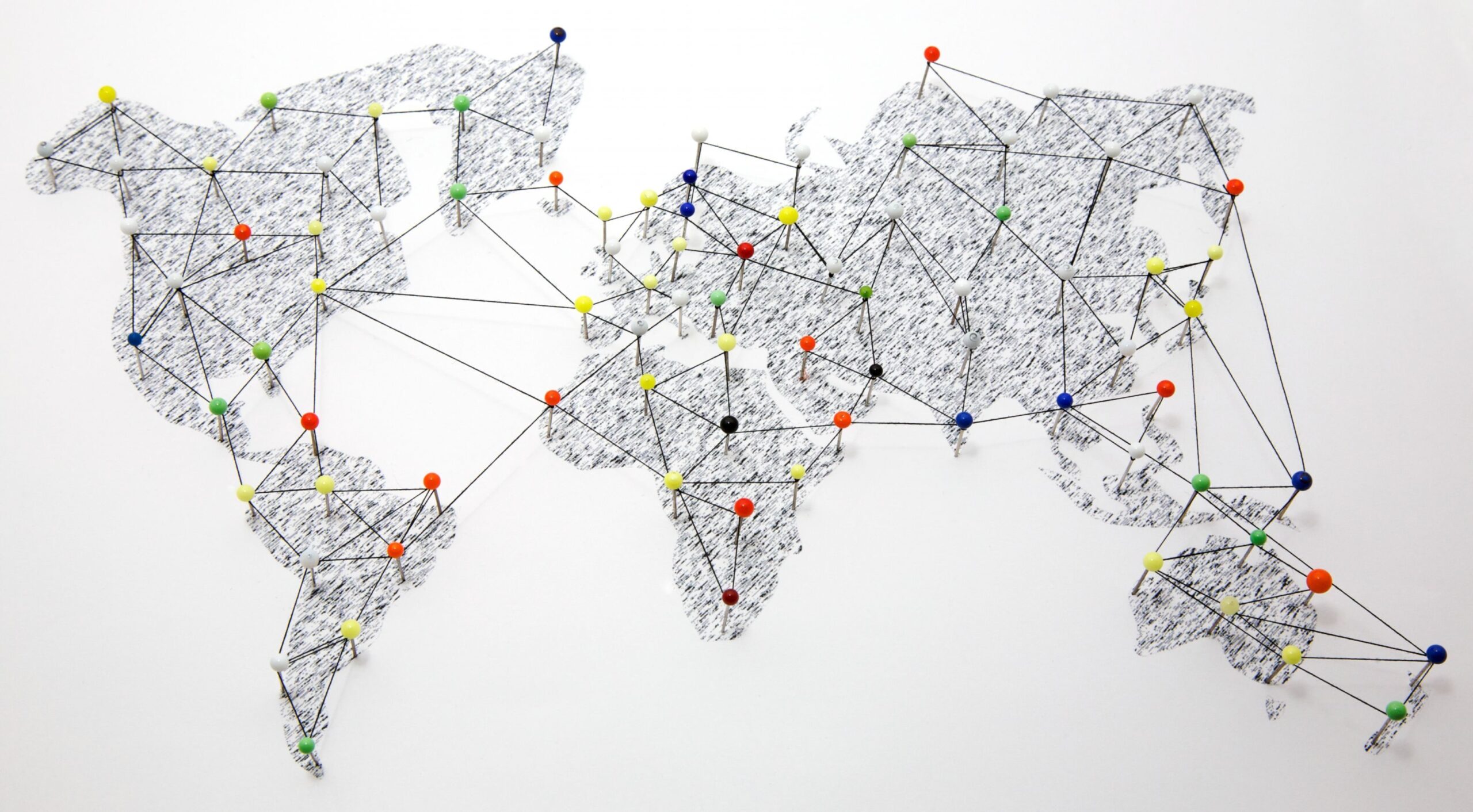 Network connections shown with pins and yarn on a world map.