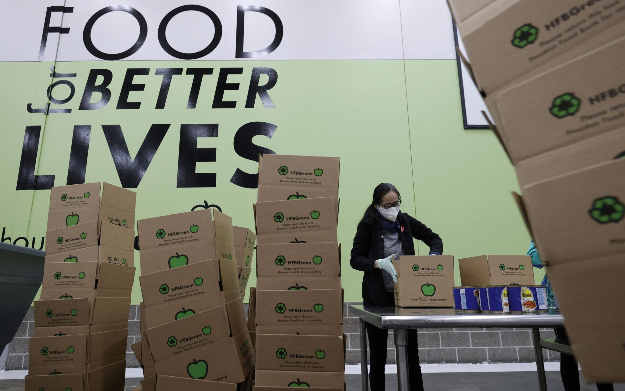 HOUSTON, TEXAS - FEBRUARY 20: A volunteer packs emergency distribution boxes at the Houston Food Bank on February 20, 2021 in Houston, Texas. The Houston Food Bank is preparing thousands of emergency food boxes that will be given out to residents in need after winter storm Uri swept across Texas and 25other states with a mix of freezing temperatures and precipitation. Much of Texas is still struggling with historic cold weather, power outages and a shortage of potable water. Many Houston residents do not have drinkable water or food at their homes and are relying on giveaways. (Justin Sullivan, Getty Images)