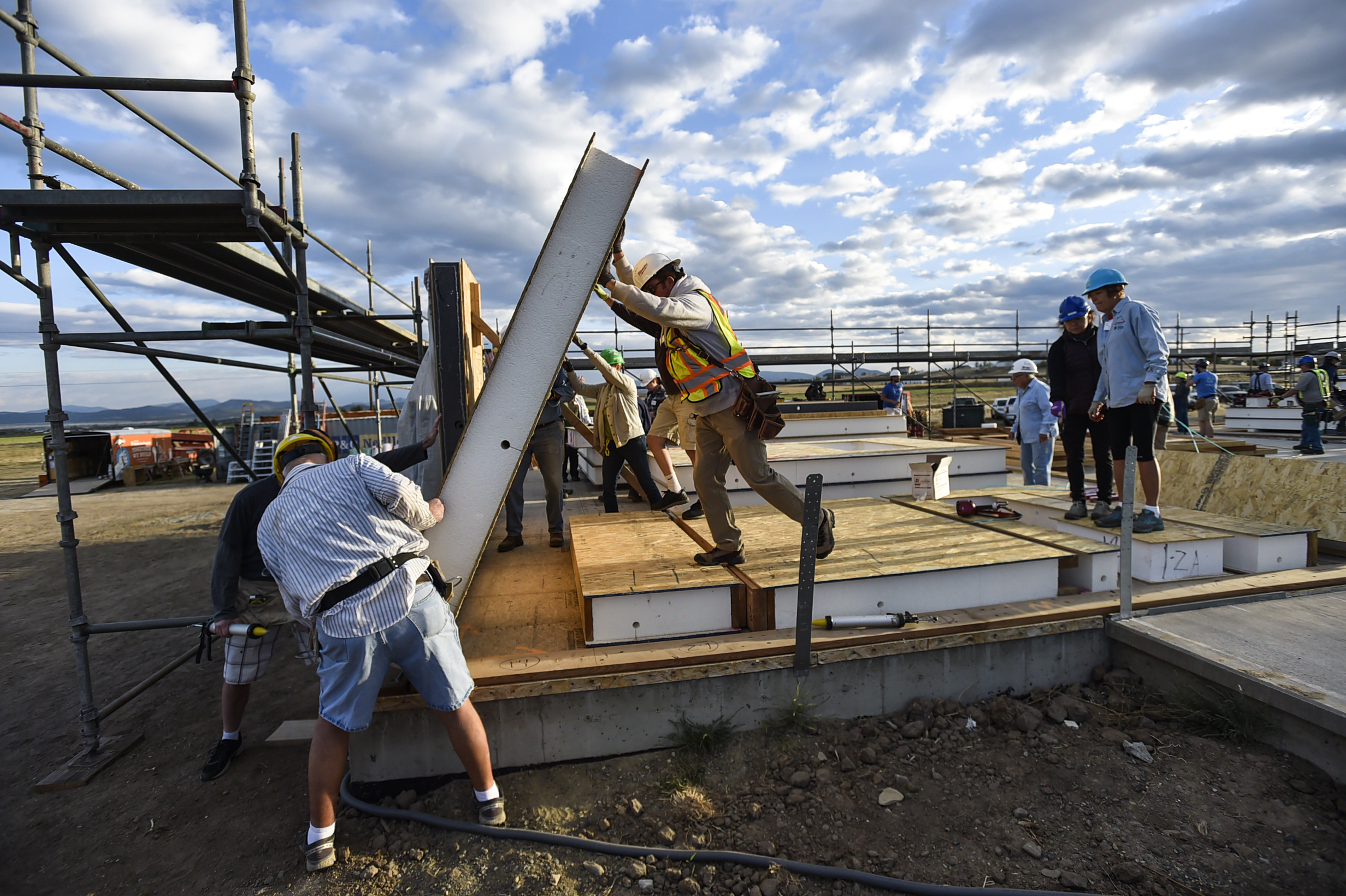 Home Builders Blitz volunteers raise one of the first walls on four homes they started constructing Thursday morning fro the Habitat for Humanity Home Builders Blitz.