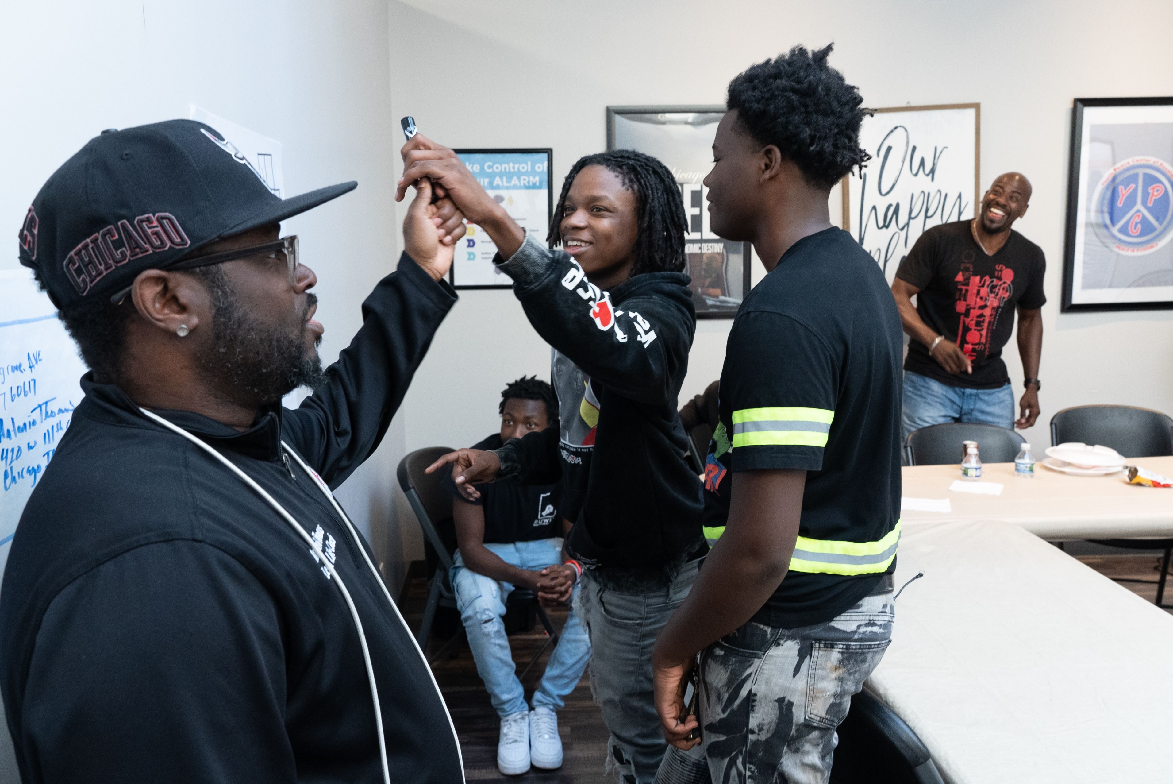Lead life coach Antonio Thomas, left, leads program participants in a whiteboard thinking exercise at The Youth Peace Center of Roseland in Chicago, Thursday, Sep. 8, 2022. At far right is former NBA player Nate Driggers.