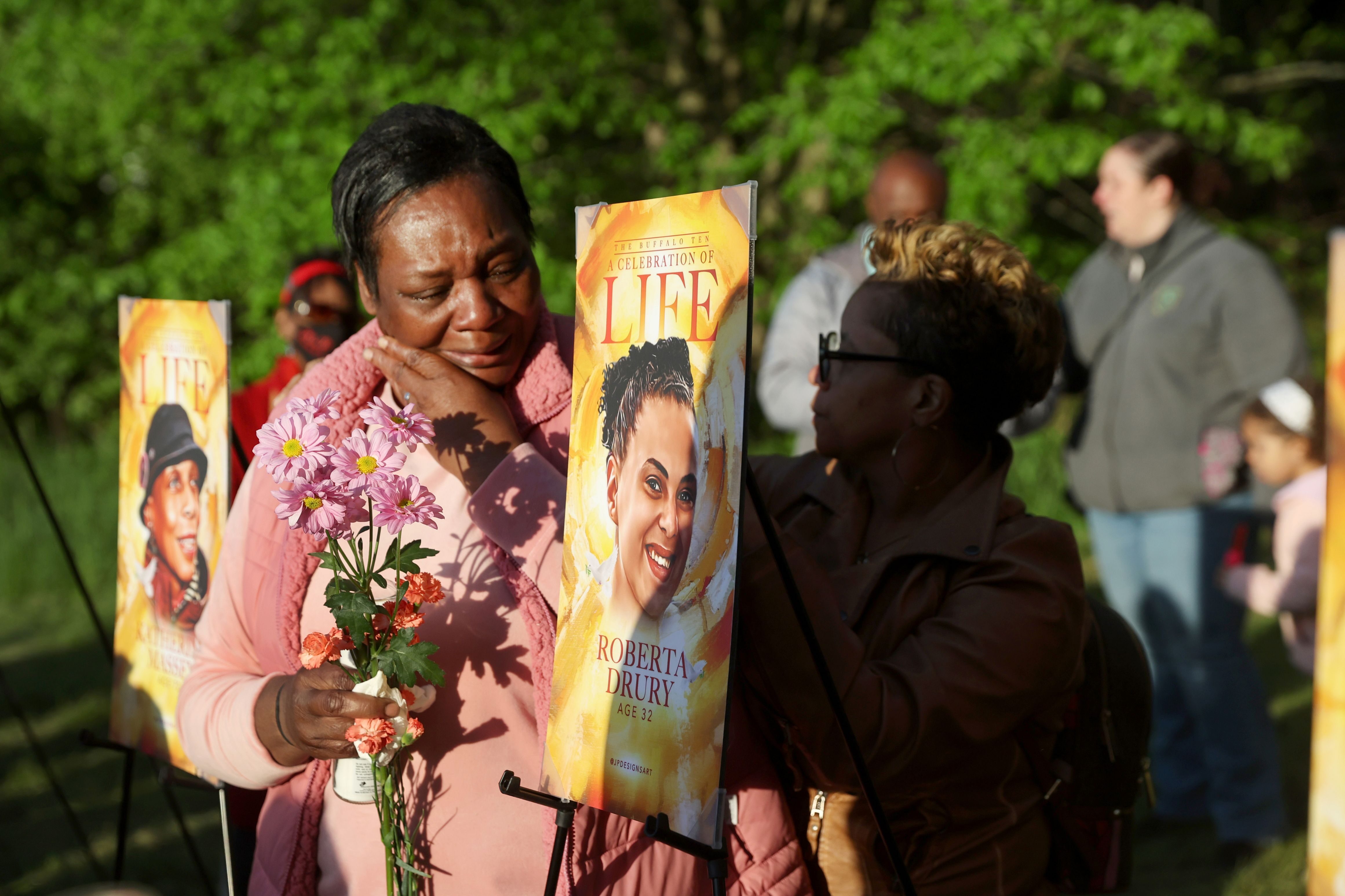 People participate in a vigil to honor the 10 people killed in Saturday’s shooting at Tops market on May 17, 2022 in Buffalo, New York.