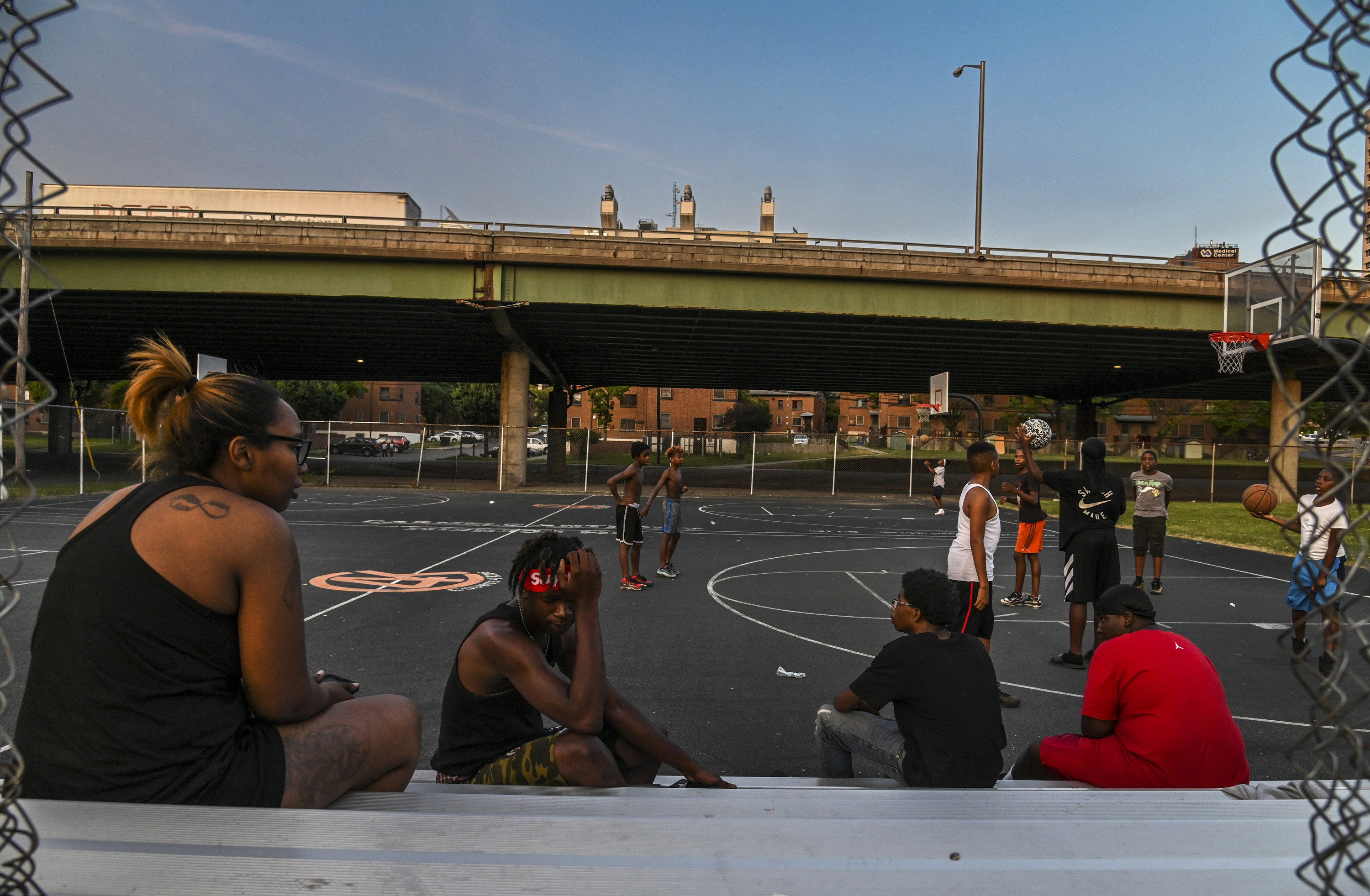 SYRACUSE, NY: Kids play basketball at Wilson Park near where highway I-81 slices through the public housing complex called Pioneer Homes in the south side of the city on Monday, July 8, 2019, in Syracuse, NY.  If this elevated section of the highway is torn down, residents hope the state will contain construction dust that threatens to increase the neighborhood's already soaring asthma rates.  The neighborhood's high rates of asthma are suspected of being correlated to living in close proximity to the highway and its traffic. (Jahi Chikwendiu, The Washington Post, Getty Images).