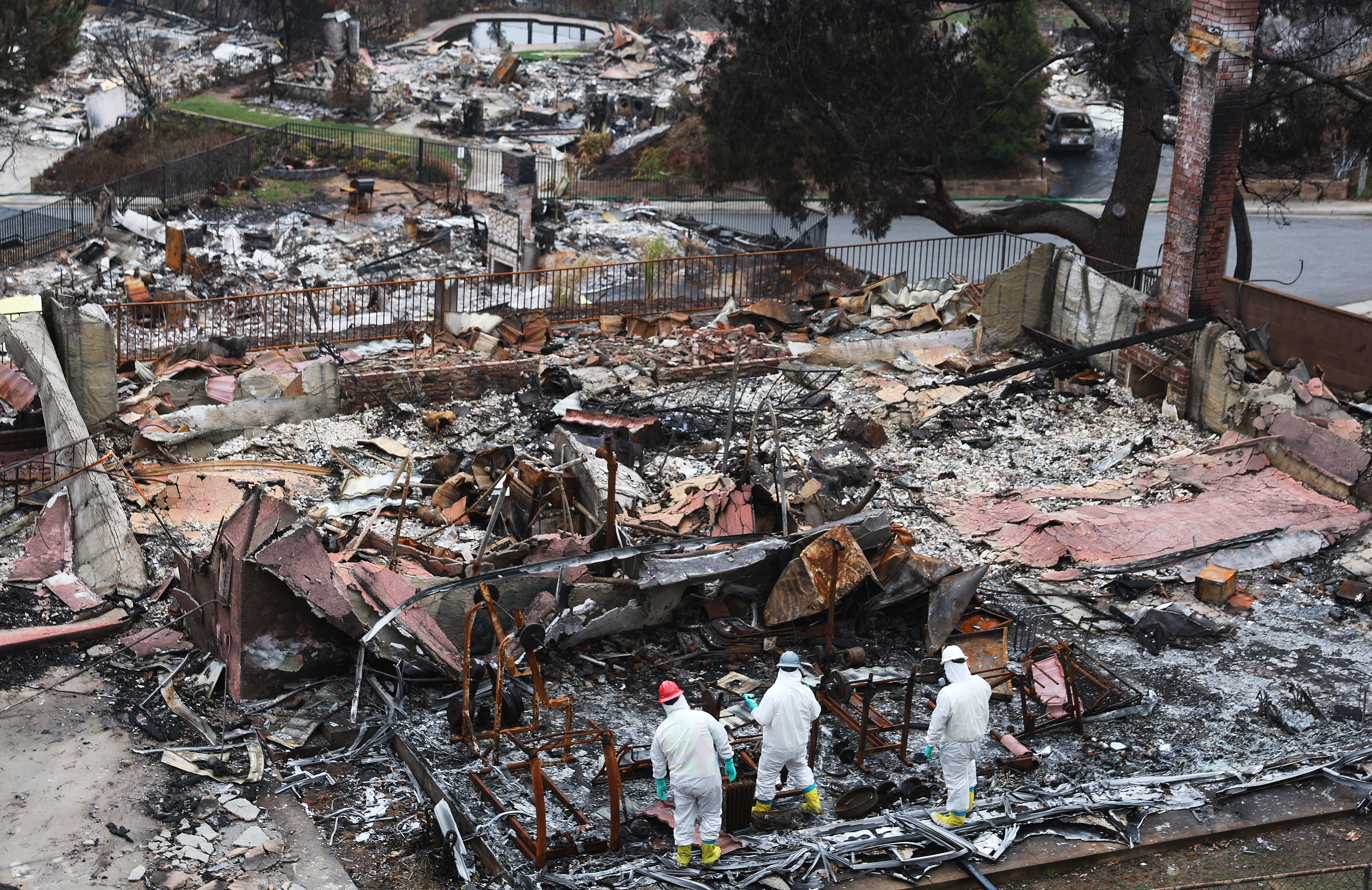 Environmental Protection Agency contractors work to remove hazardous waste from a home destroyed in the Eaton Fire on February 12, 2025 in Altadena, California.