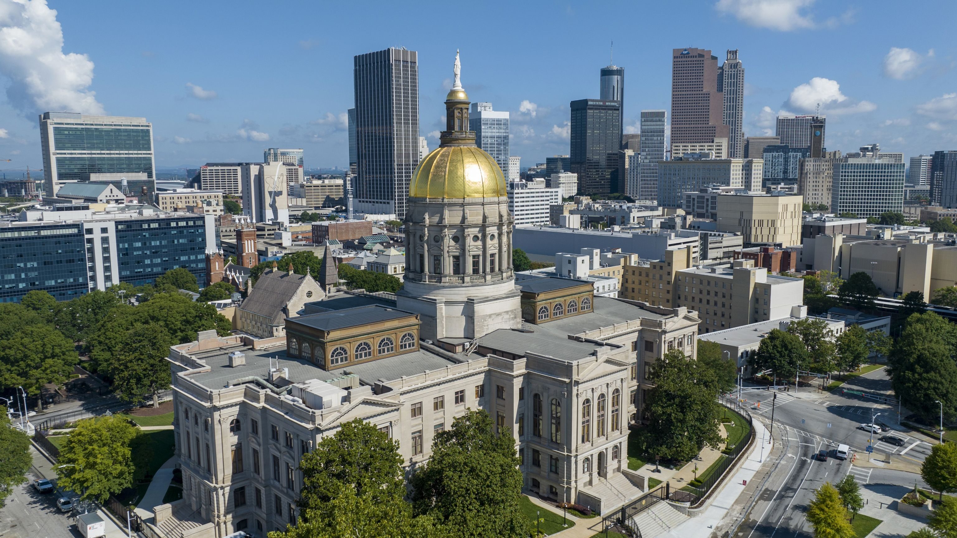 The gold dome of the Georgia State Capitol gleams in the sun in front of the skyline of downtown Atlanta, Ga., Saturday, Aug. 27, 2022.