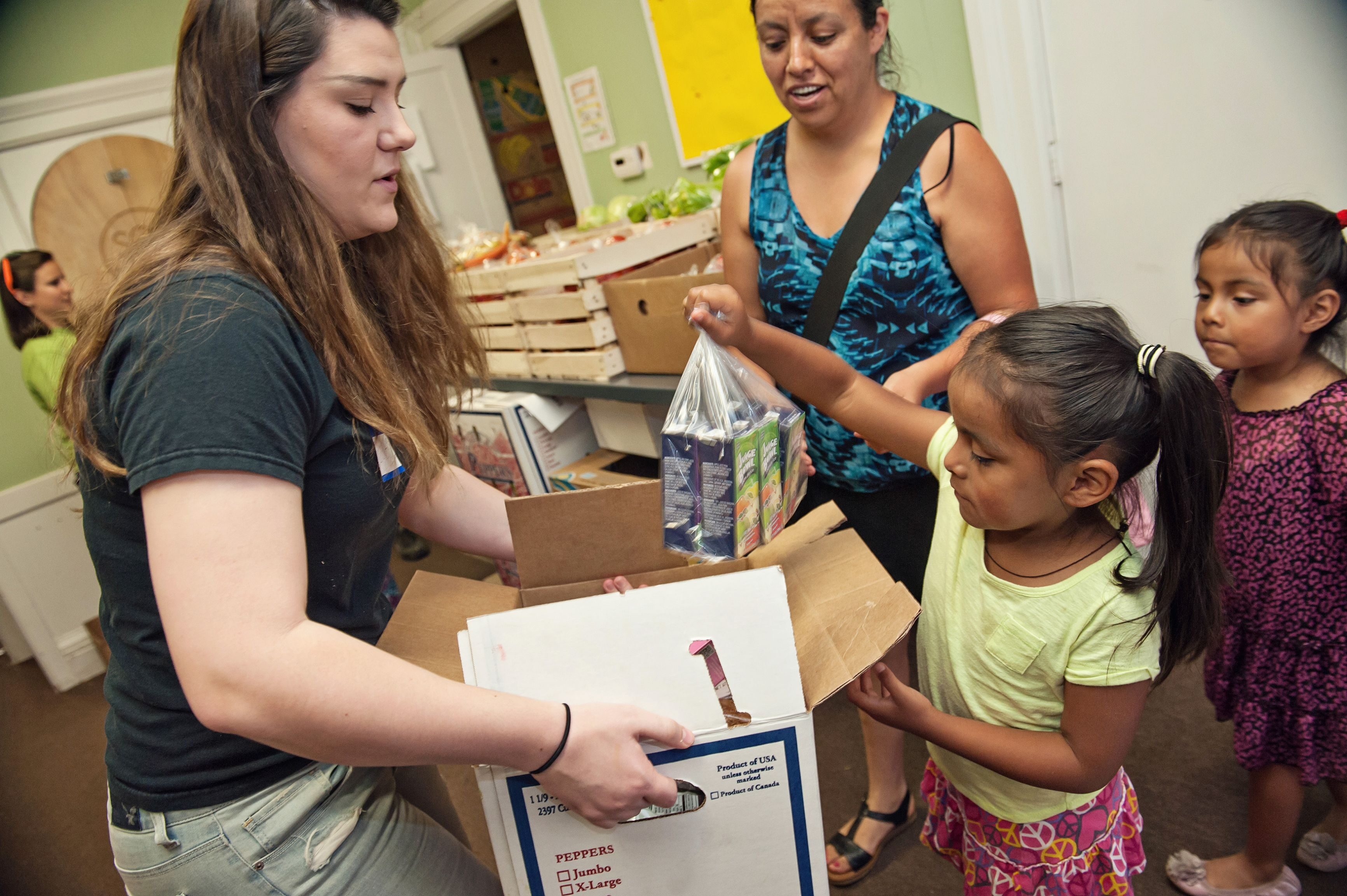 An SOS volunteer helps a family gather food from the SOS Community Services’ pantry in Ypsilanti, Mich.