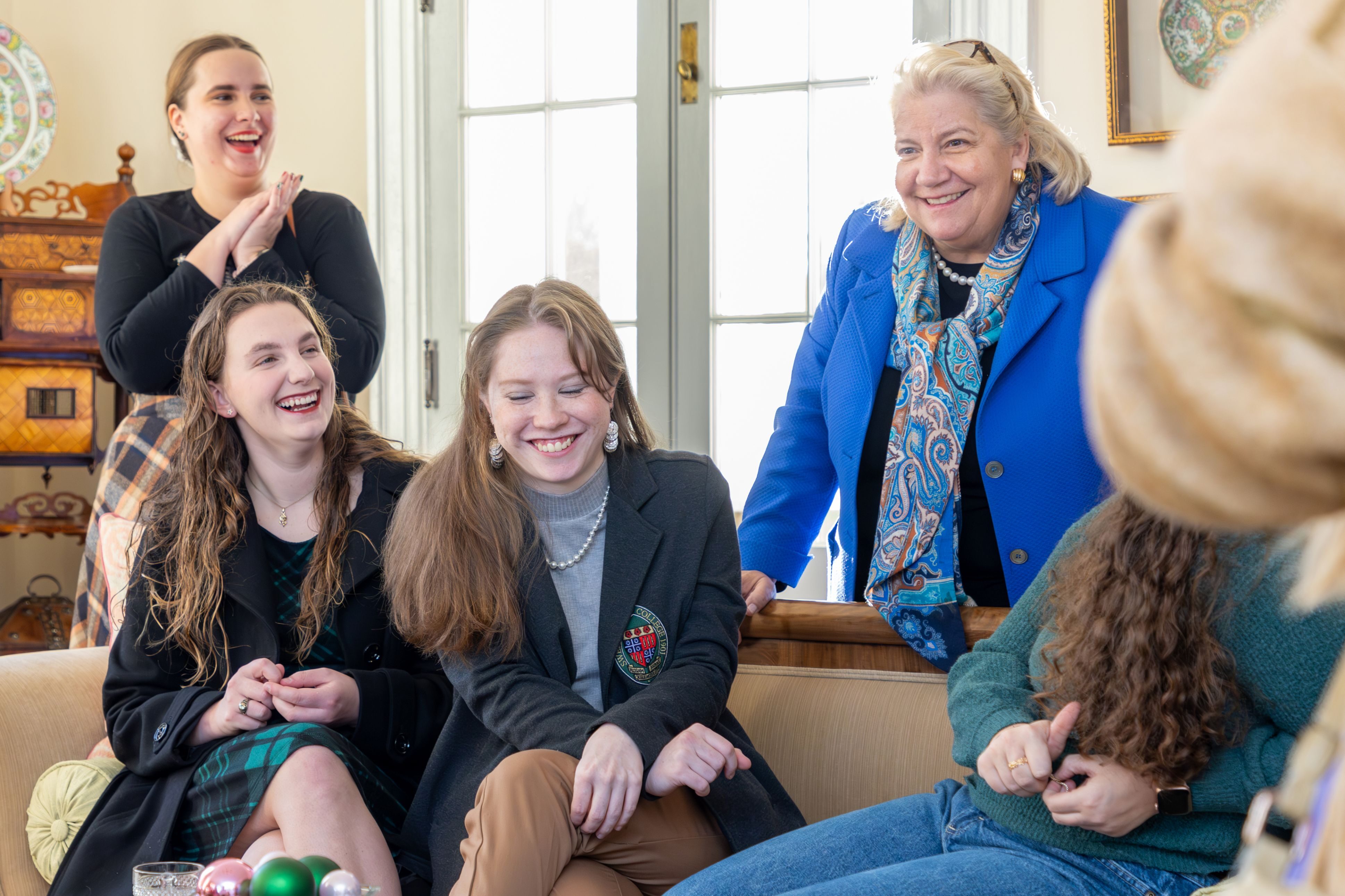 Sweet Briar College President Mary Pope Maybank Hutson, at right, joins students during a holiday gathering at the president’s home.
