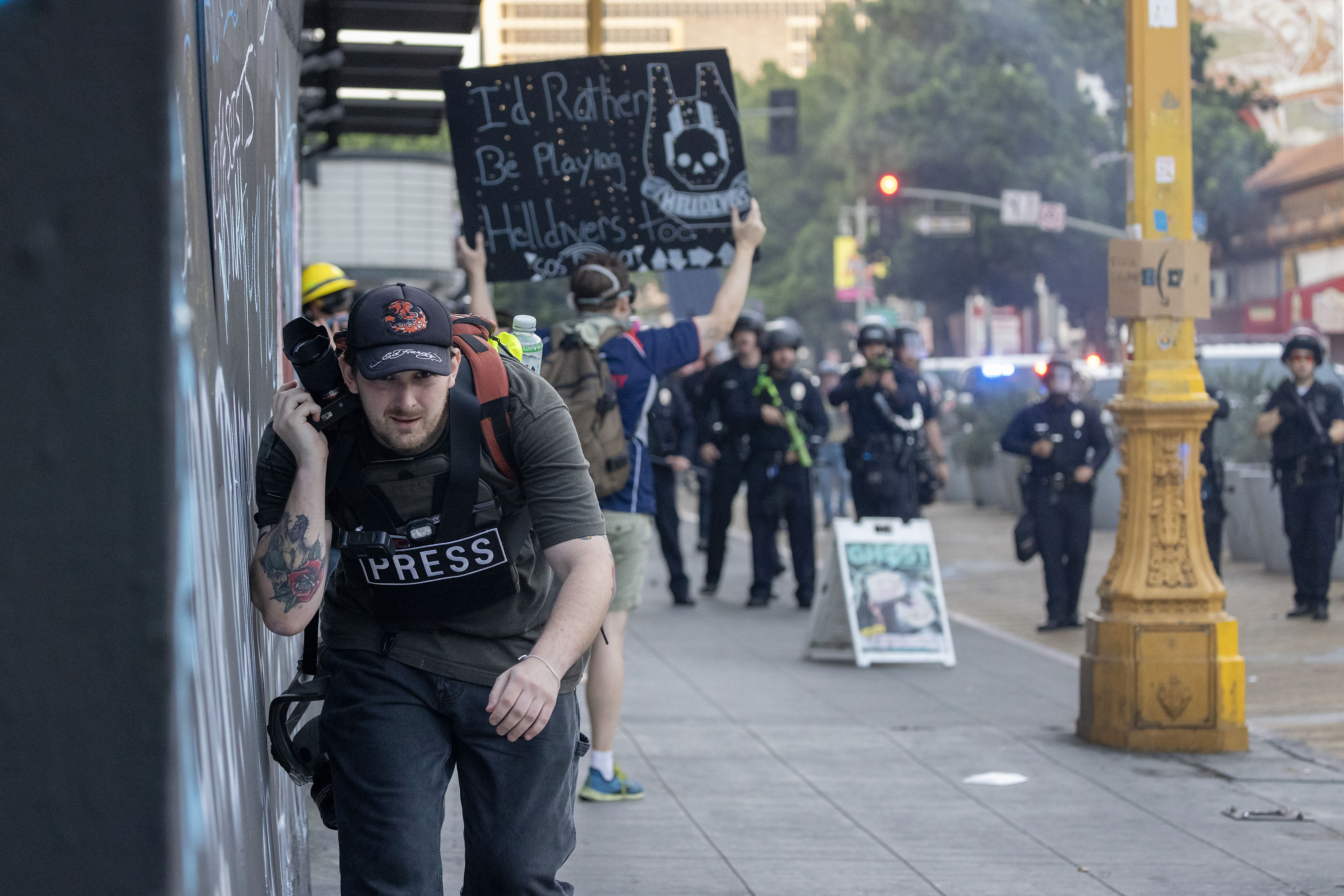A member of the Press runs as police shoot less-than-lethal munitions during a "No Kings" protest in the one-square mile area where daily protests have been occurring in response to a series of federal immigration raids in Los Angeles, Calif., on June 14, 2025.