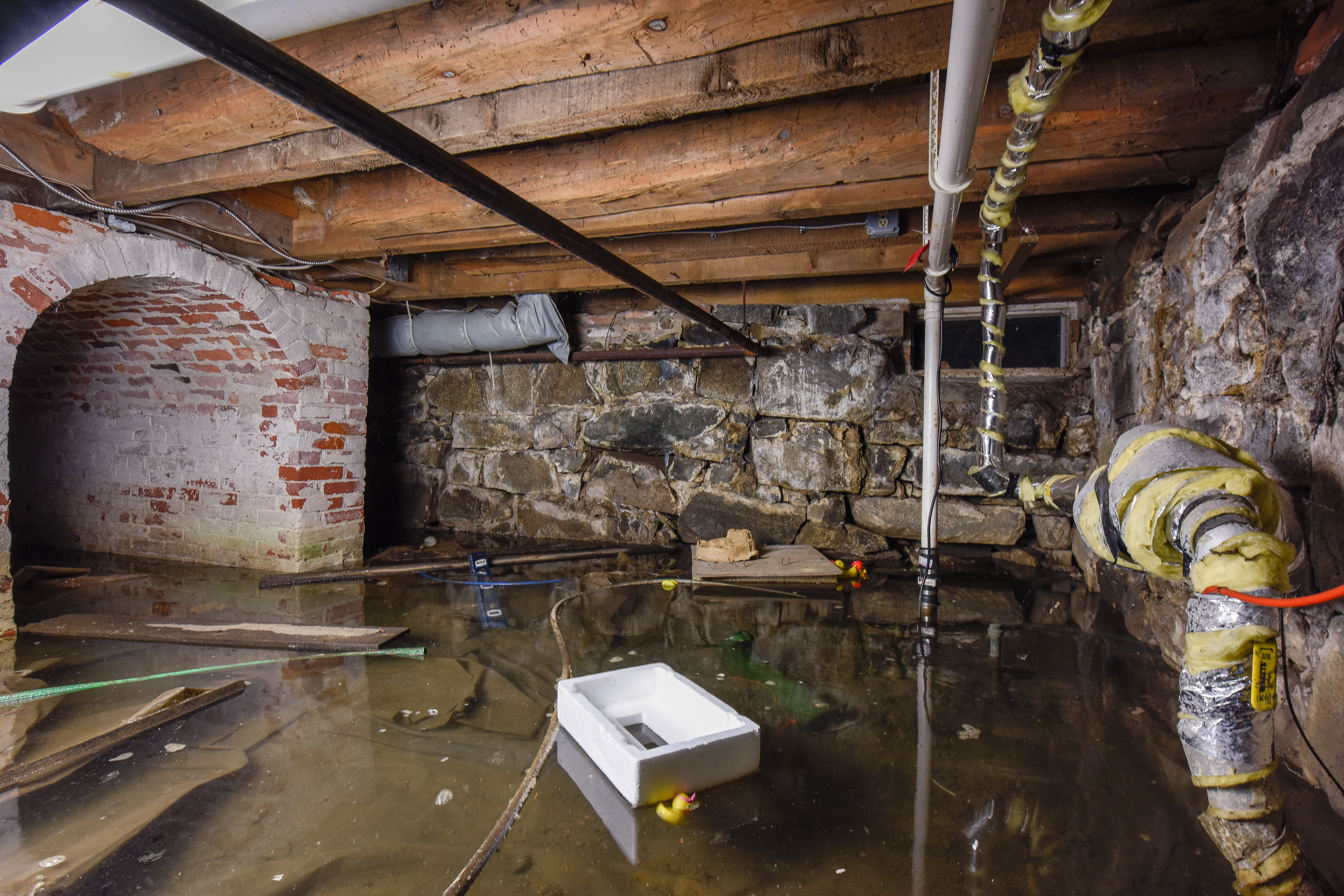 The Strawberry Banke Museum in Portsmouth, N.H., is a 10-acre campus with 32 historic buildings. Groundwater flooding (as seen in this photo of a flooded basement) made worse by climate change poses a threat to the buildings in the form of mold, mildew, crumbling foundation stones, and other problems. The museum has started to elevate some of the buildings.