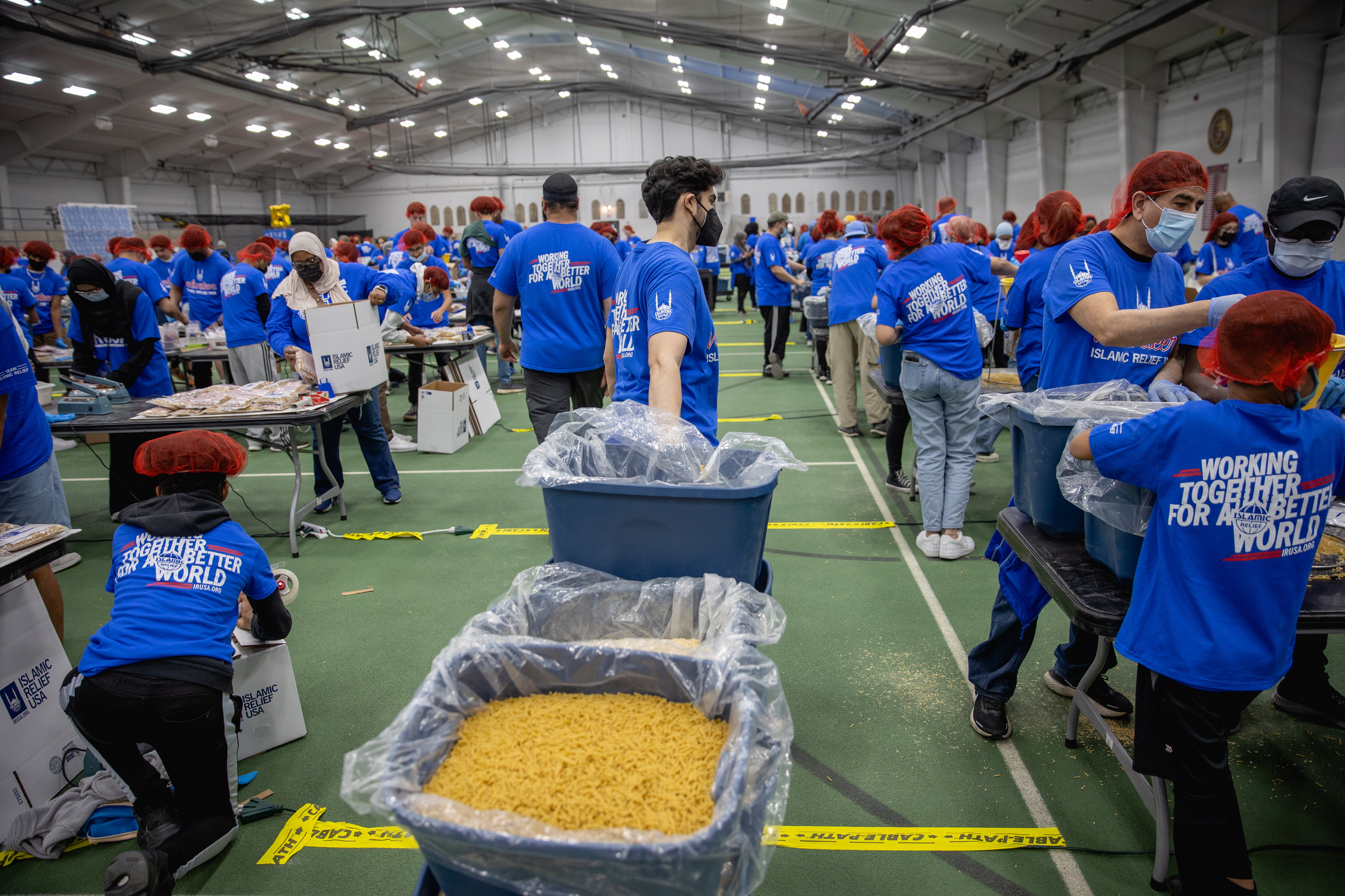 Islamic Relief USA volunteers distribute refills of the dry ingredients for the meals at our 125K Meal Pack in Alexandria, VA. On the last day of the holy month of Ramadan, over 400 volunteers came together to pack meals for those in need. In a matter of two hours, 157,000 meals were packed in total.