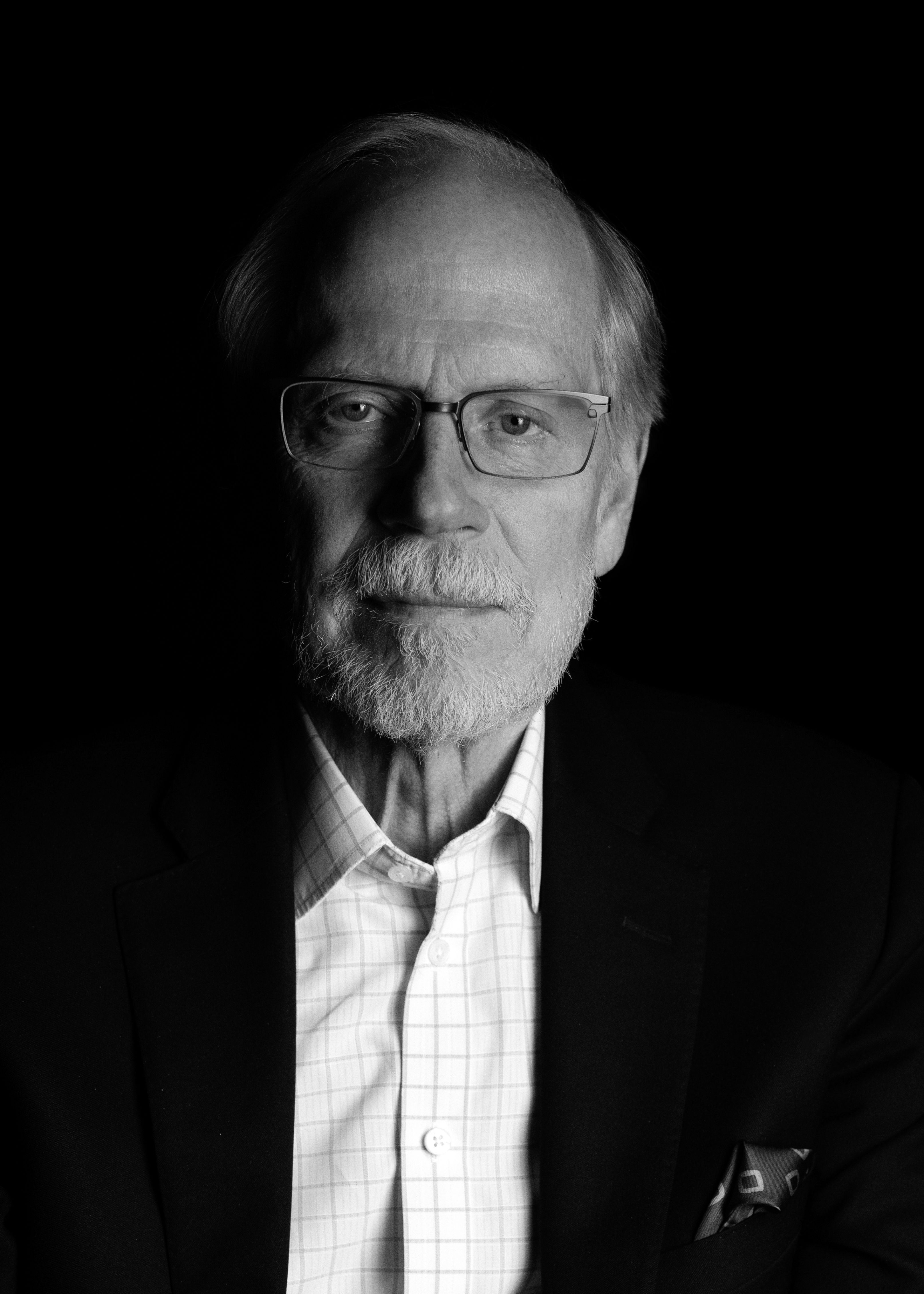 a black and white photo portrait of Stephen Heintz, wearing a suit jacket and no tie.
