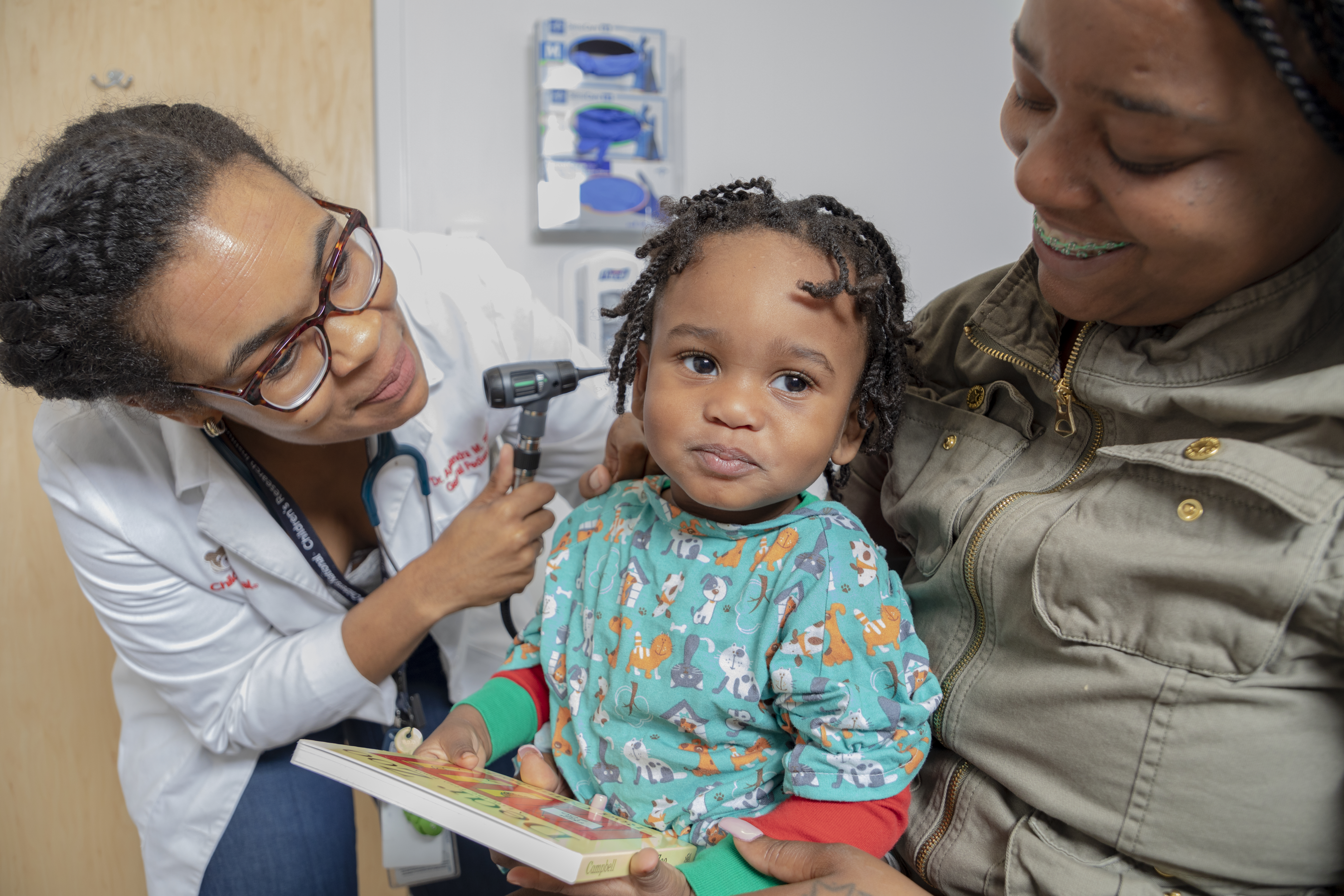 A pediatrician with a young child and their mother at a HealthySteps site in Children’s National Hospital in Washington, DC.
