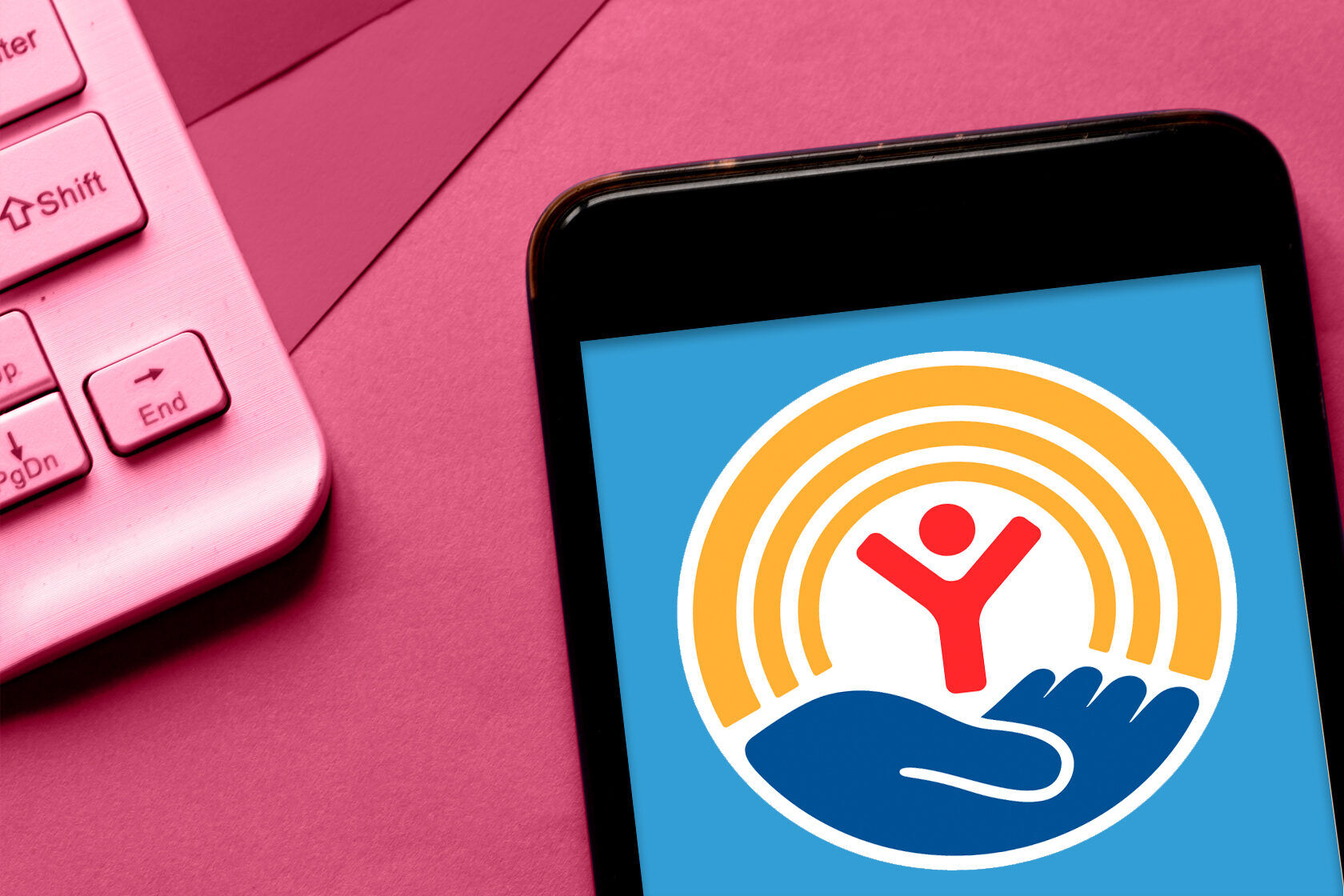 Photo illustration of phone with logo against pink background