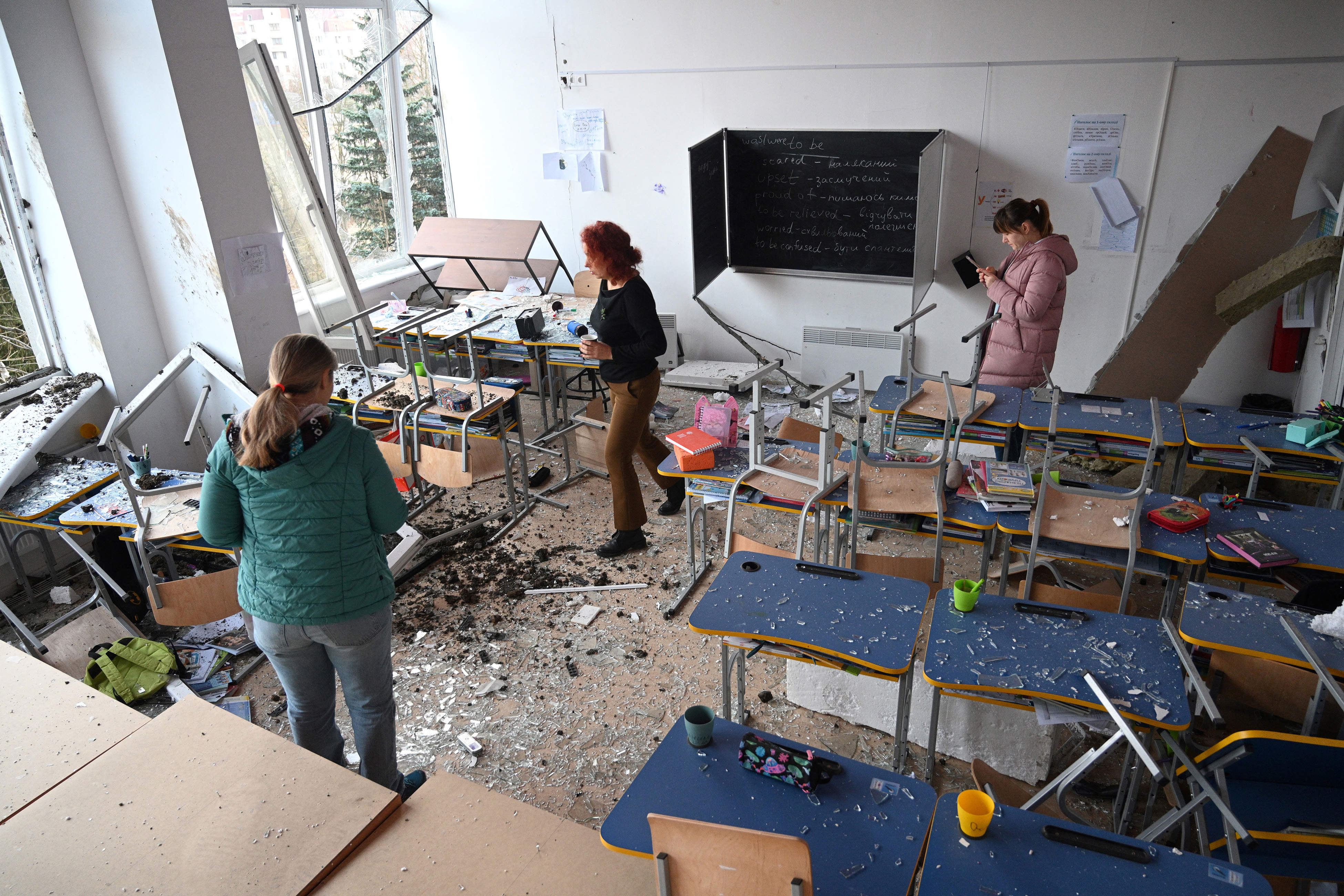 School employees inspect a classroom damaged as a result of a missile attack in Lviv, western Ukrainian city, on February 15, 2024, amid the Russian invasion in Ukraine. Ukraine was under a nationwide air alert for over two hours on February 15, 2024 after the military warned that a group of bombers had taken off from a base in Russia. (Yuriy Dyachsyshyn, AFP, Getty Images)