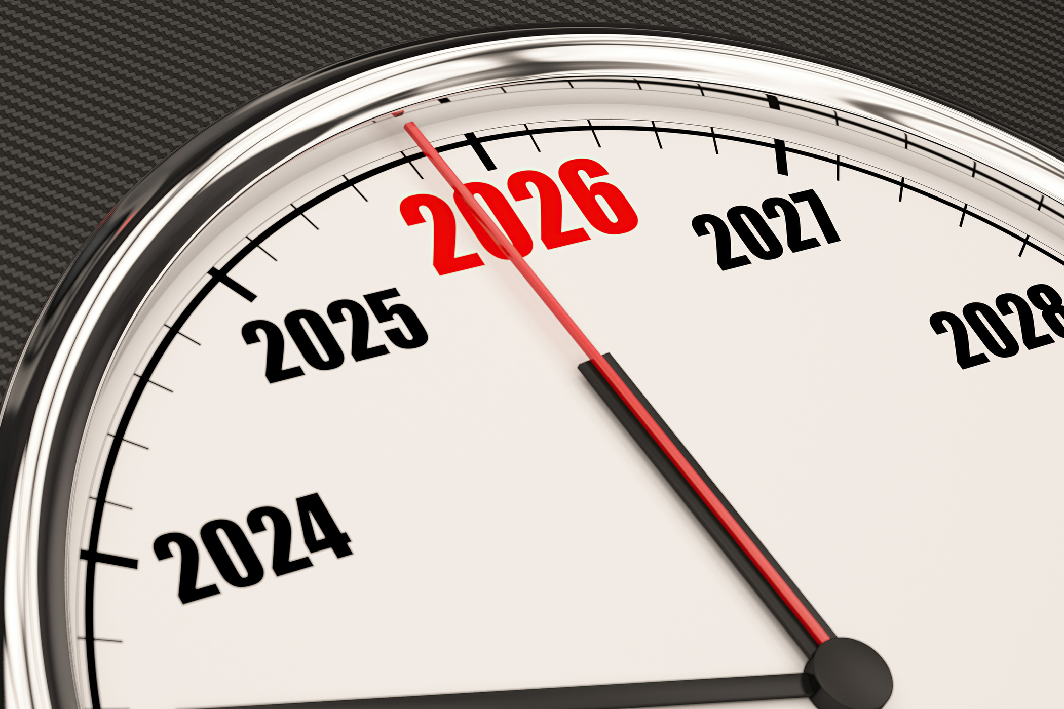 A clock face with a red hand pointing to the year 2026, which is highlighted in red. Other years like 2024, 2025, 2027, 2028 are also visible on the white dial, encased in a chrome bezel against a dark textured background.